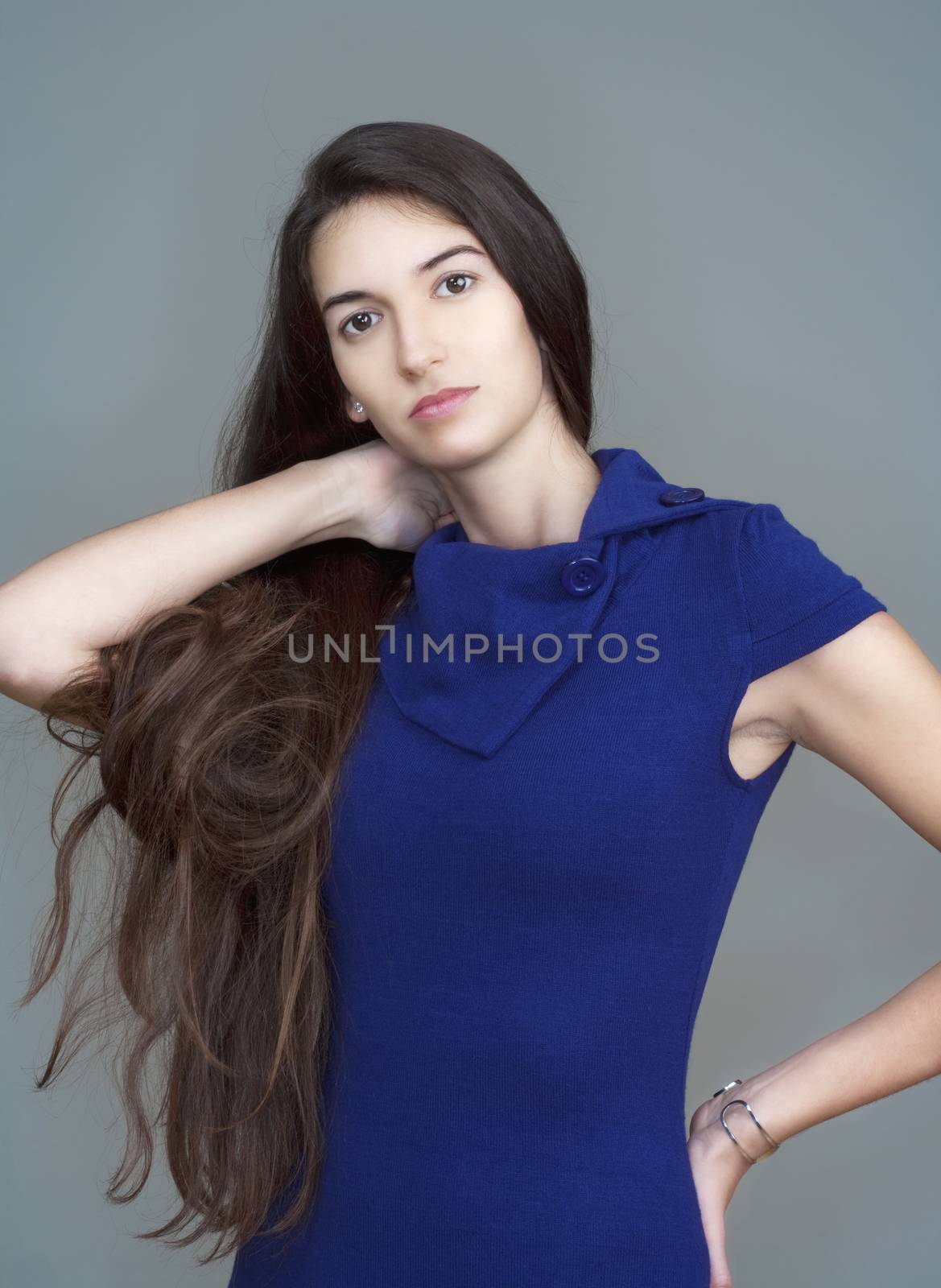 beautiful woman in blue dress with long brown hair - isolated on gray