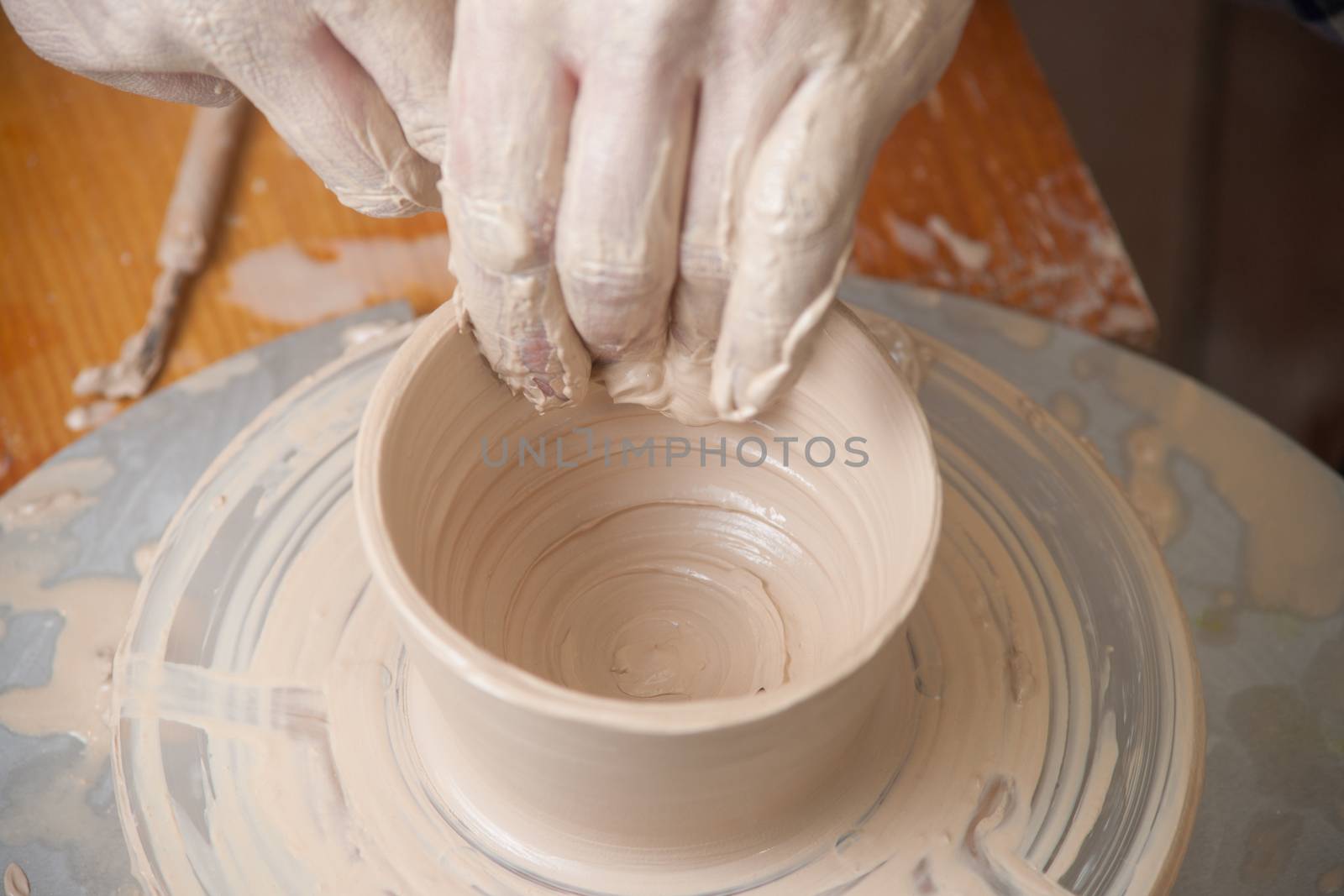 Hands of a potter, creating an earthen jar on the circle