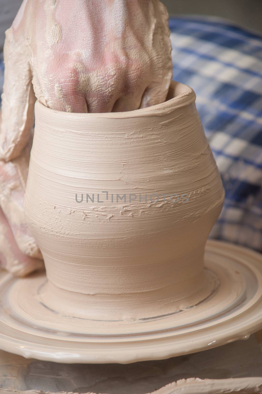 Hands of a potter, creating an earthen jar on the circle