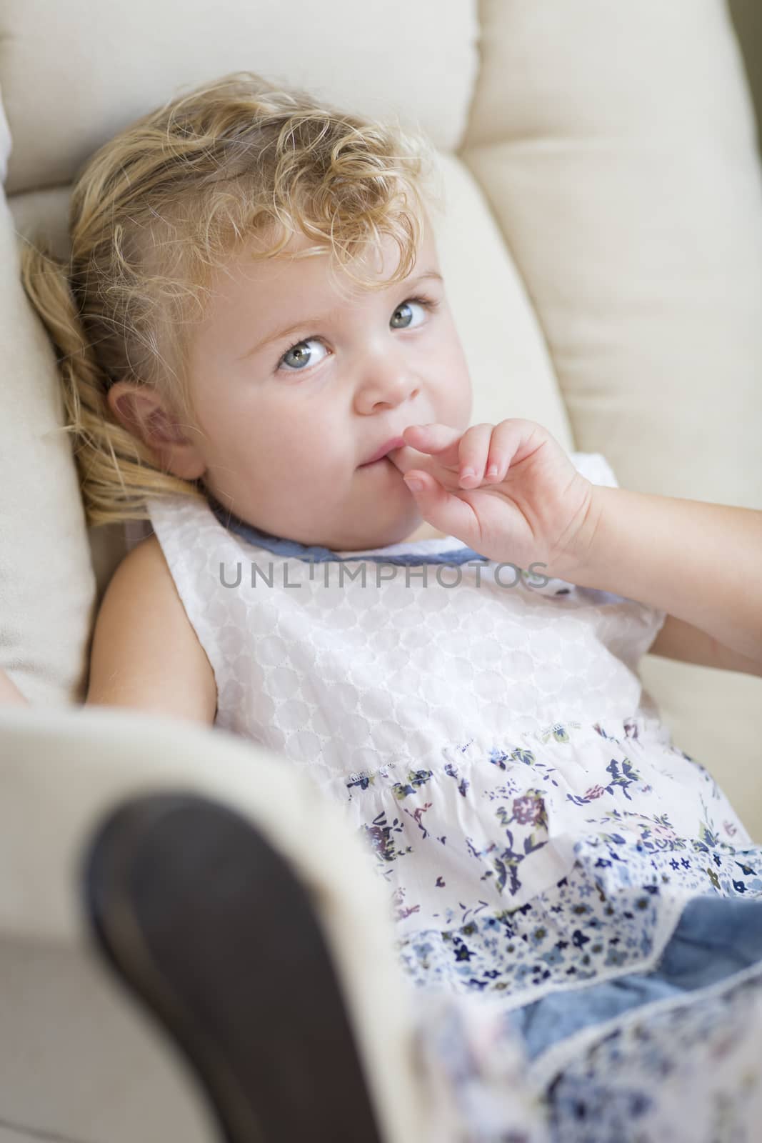 Adorable Blonde Haired and Blue Eyed Little Girl Sitting in Chair.