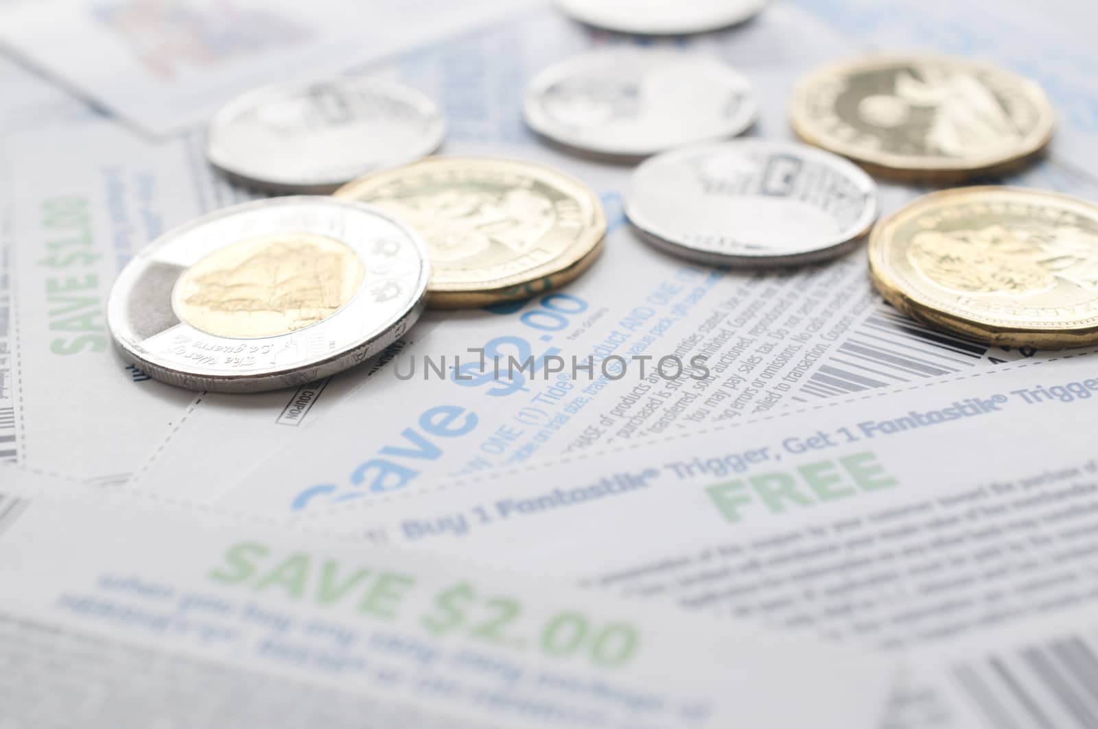 Coquitlam BC Canada - July 22, 2014 : Canadian saving coupons with money, focus on two dollar saving coupon. All coupons for Canadian store, they are issued by manufacturers of consumer packaged goods Canada.  