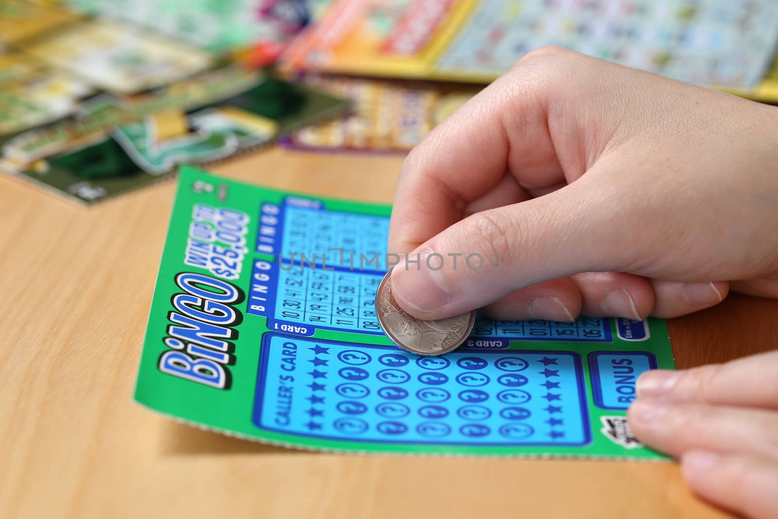 Coquitlam BC Canada - June 15, 2014 : Woman scratching lottery ticket called Bingo. It's published by BC Lottery Corporation has provided government sanctioned lottery games.