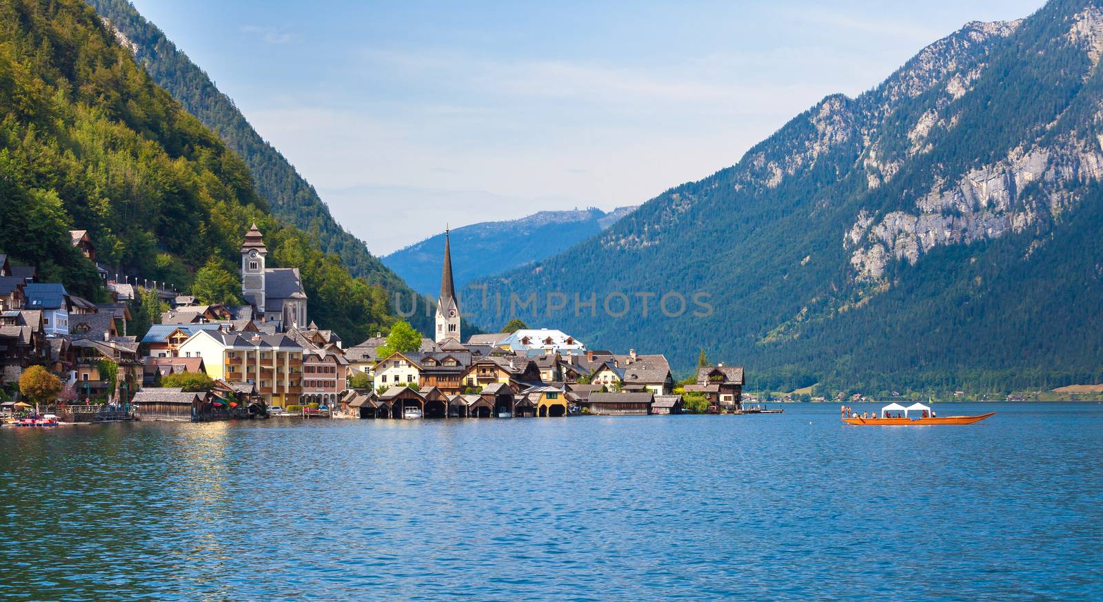 Panoramic view of Hallstatt village with traditional boat on lake, Hallstatt, Austria