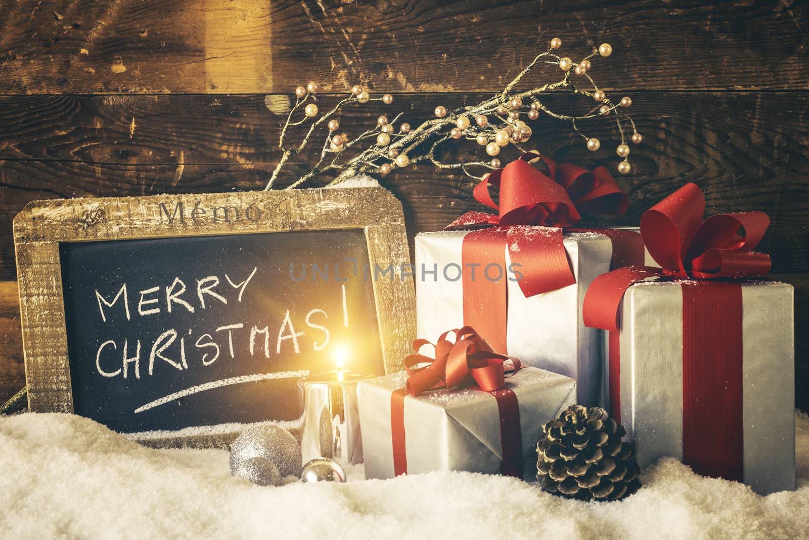 Closeup of Christmas gifts with candle and slate.