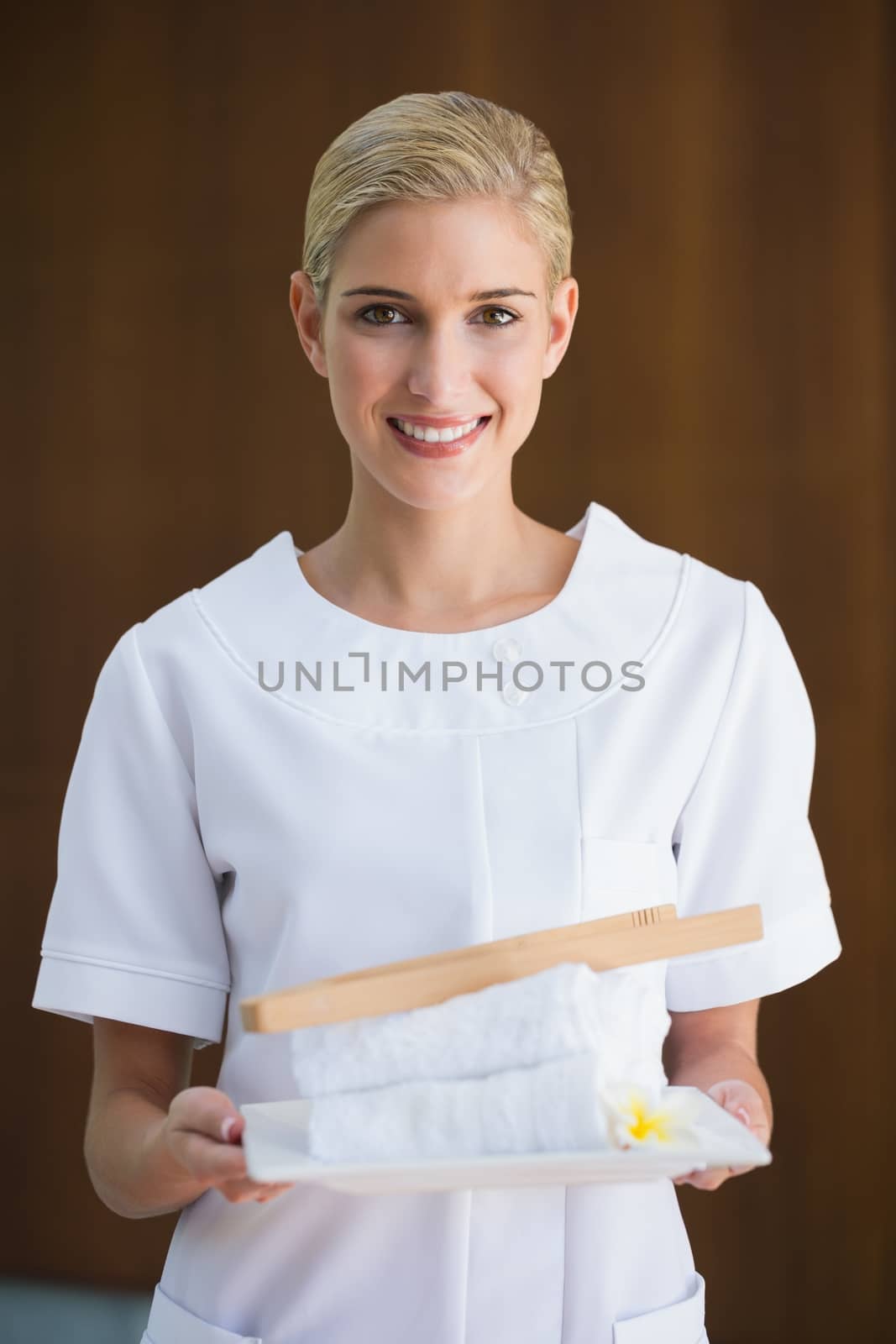 Smiling beauty therapist holding white towels by Wavebreakmedia