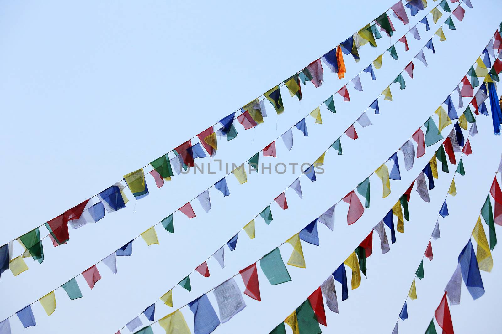 Buddhist tibetan prayer flags waving in the wind against blue sky. Nepal