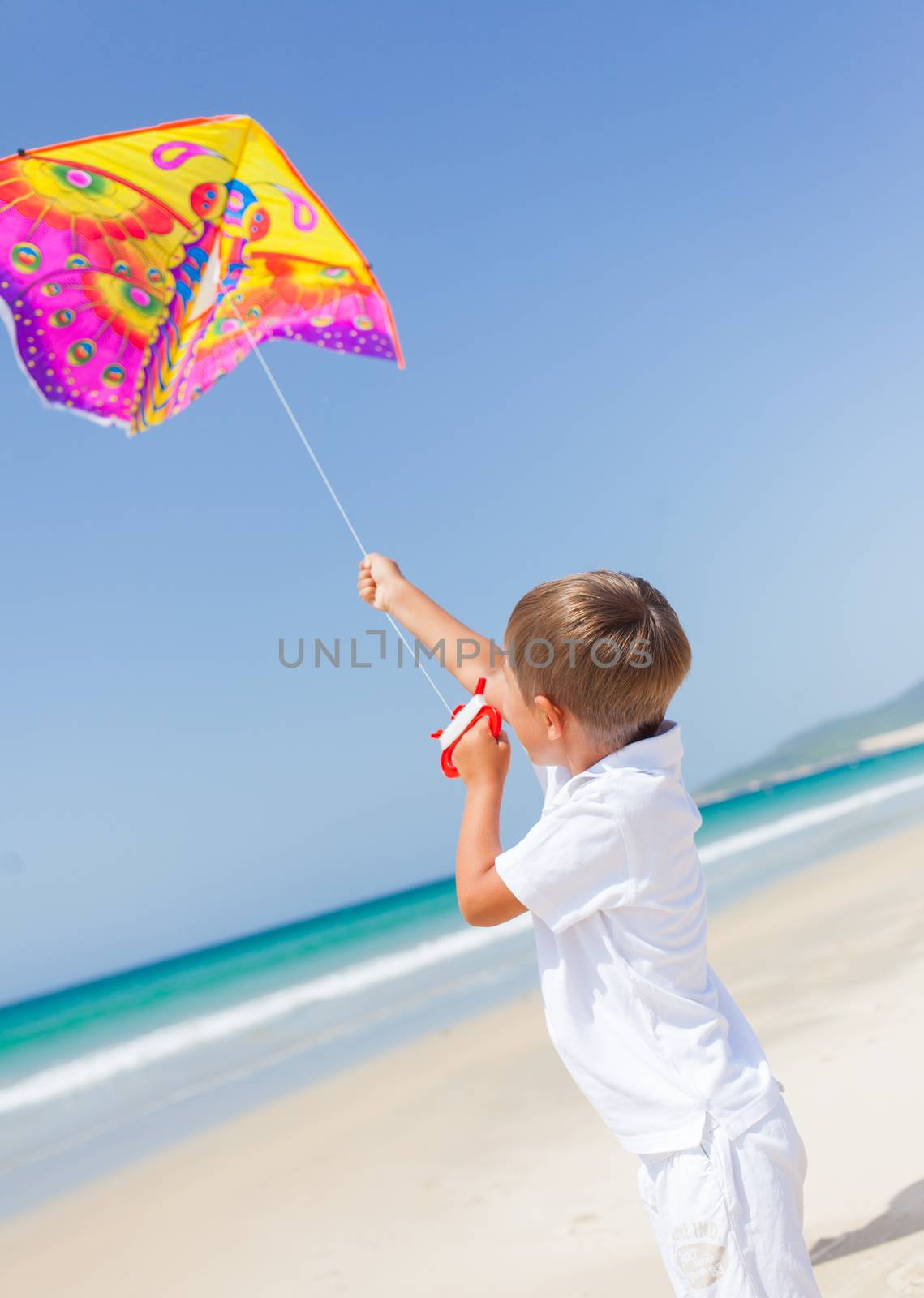Child flying kite beach outdoor. by maxoliki