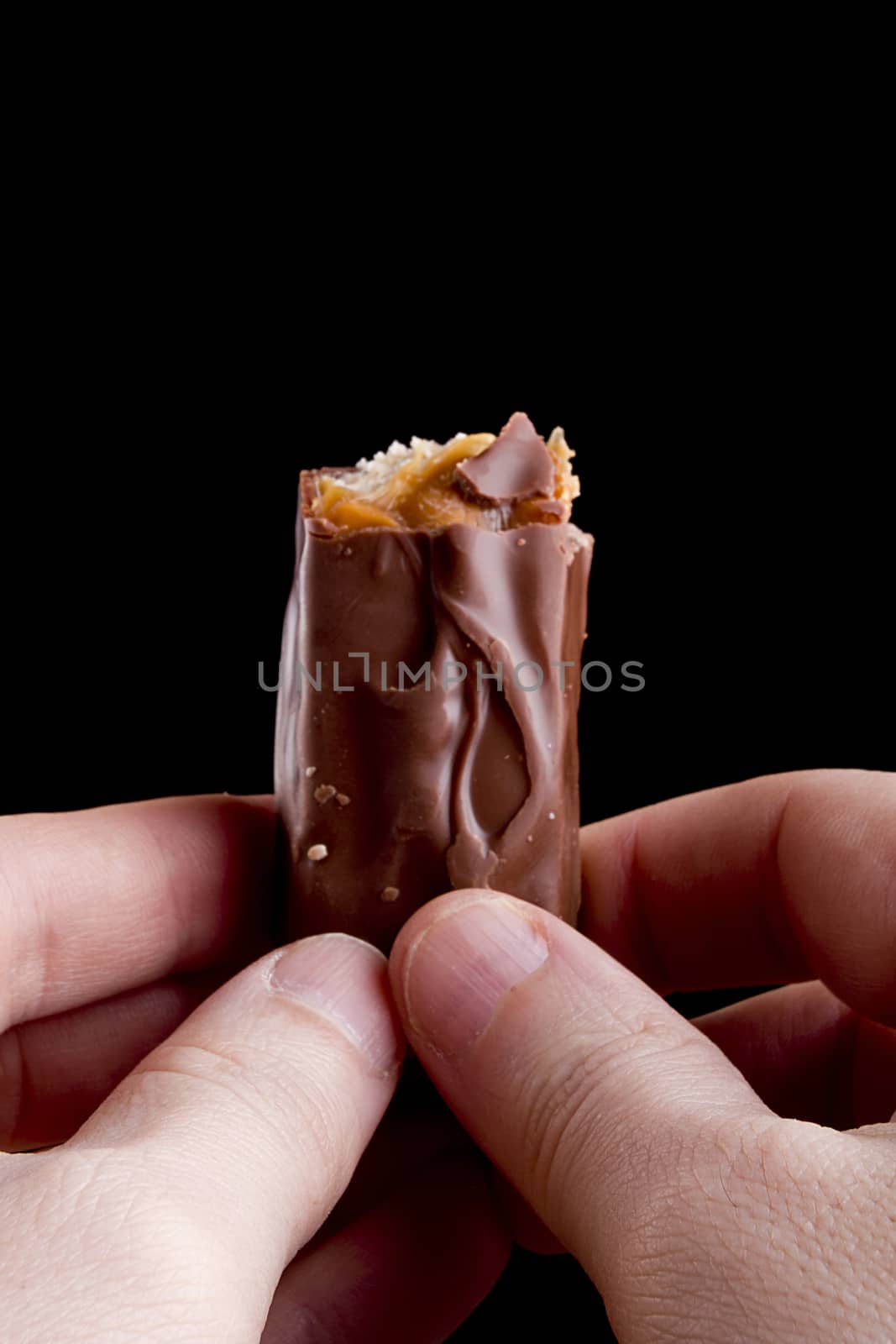 Chocolate bar with caramel filling in the hands.