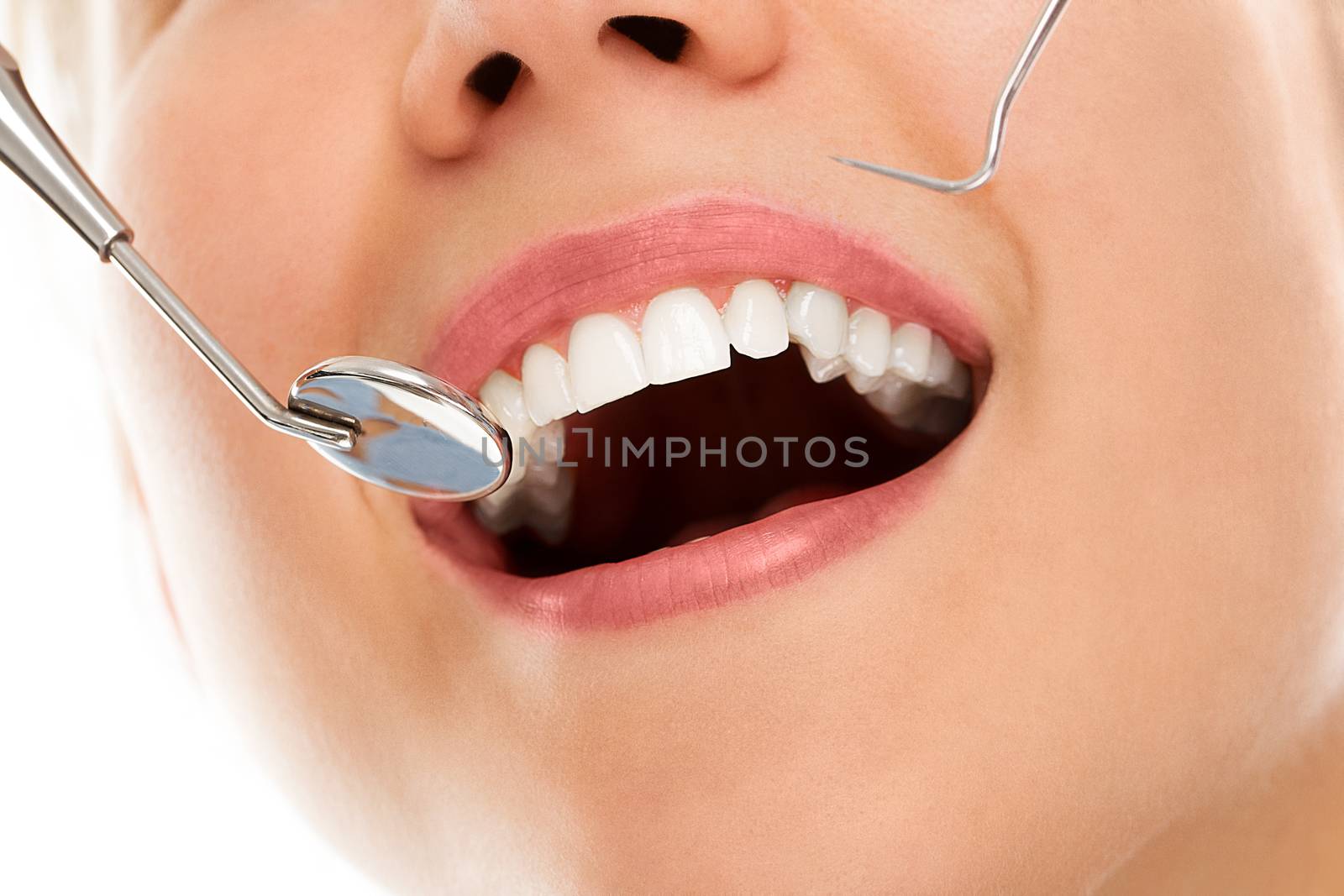 A woman is smiling while being at the dentist