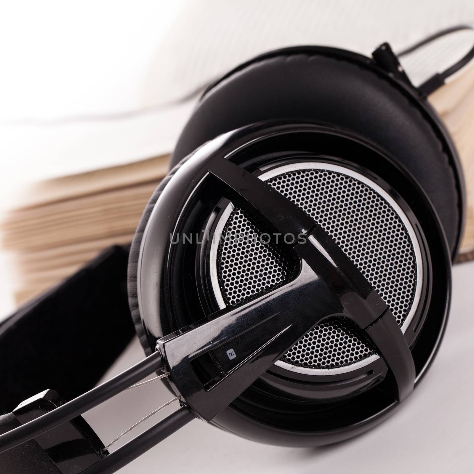 Big headphones and book on a white background