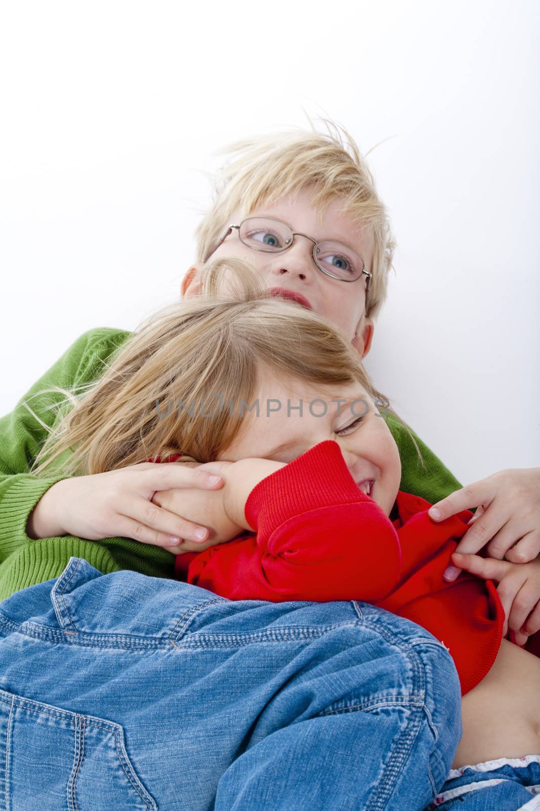 two young siblings fooling around with each other - isolated on white