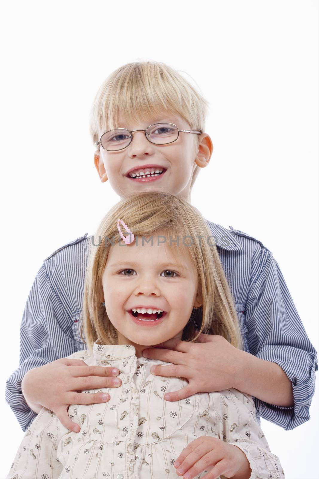 portrait of two young siblings looking at camera, smiling - isolated on white