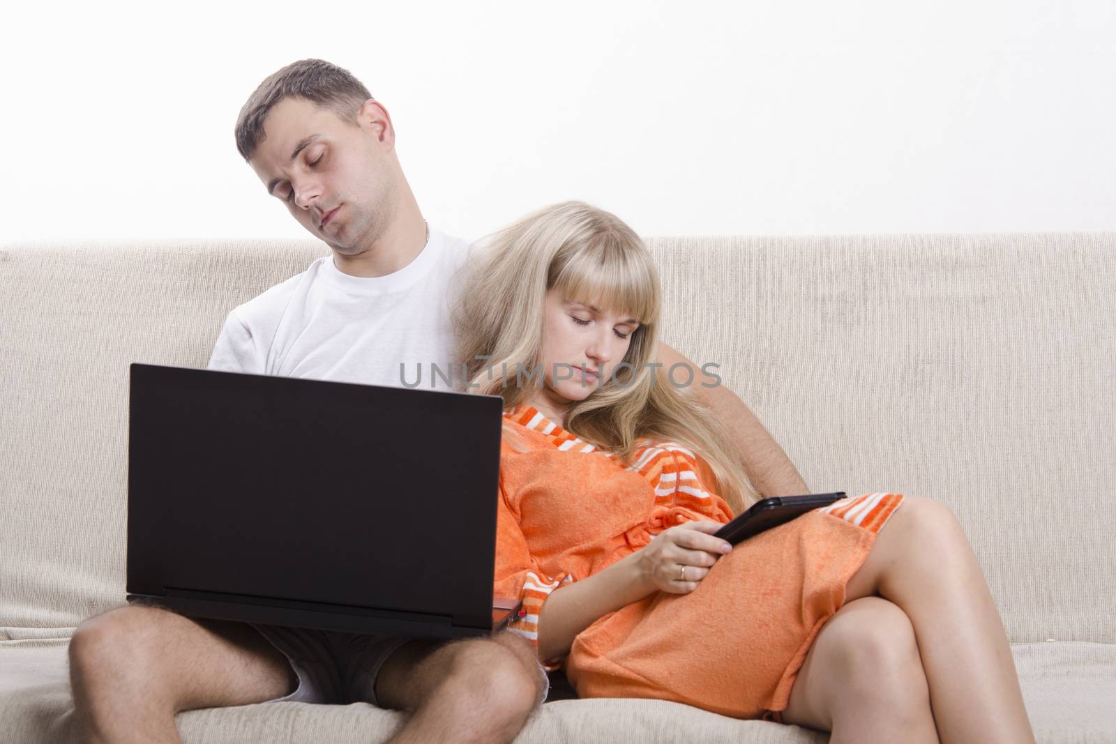 A boy and a girl sitting on the couch. A guy sitting with a laptop, a girl with a tablet. The girl clung. Both fell asleep.