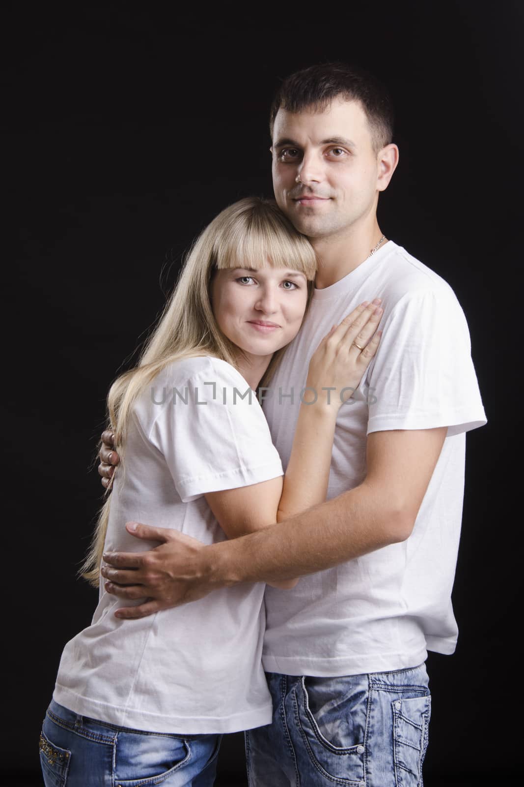 Portrait of a young couple on black background by Madhourse