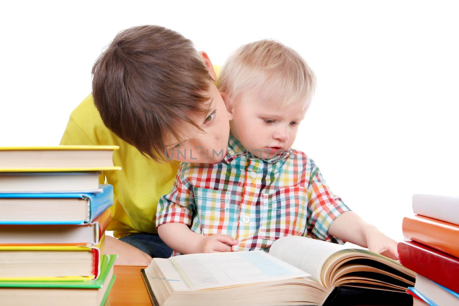 Kid and Baby Boy with the Books at the Desk Isolated on the White Background