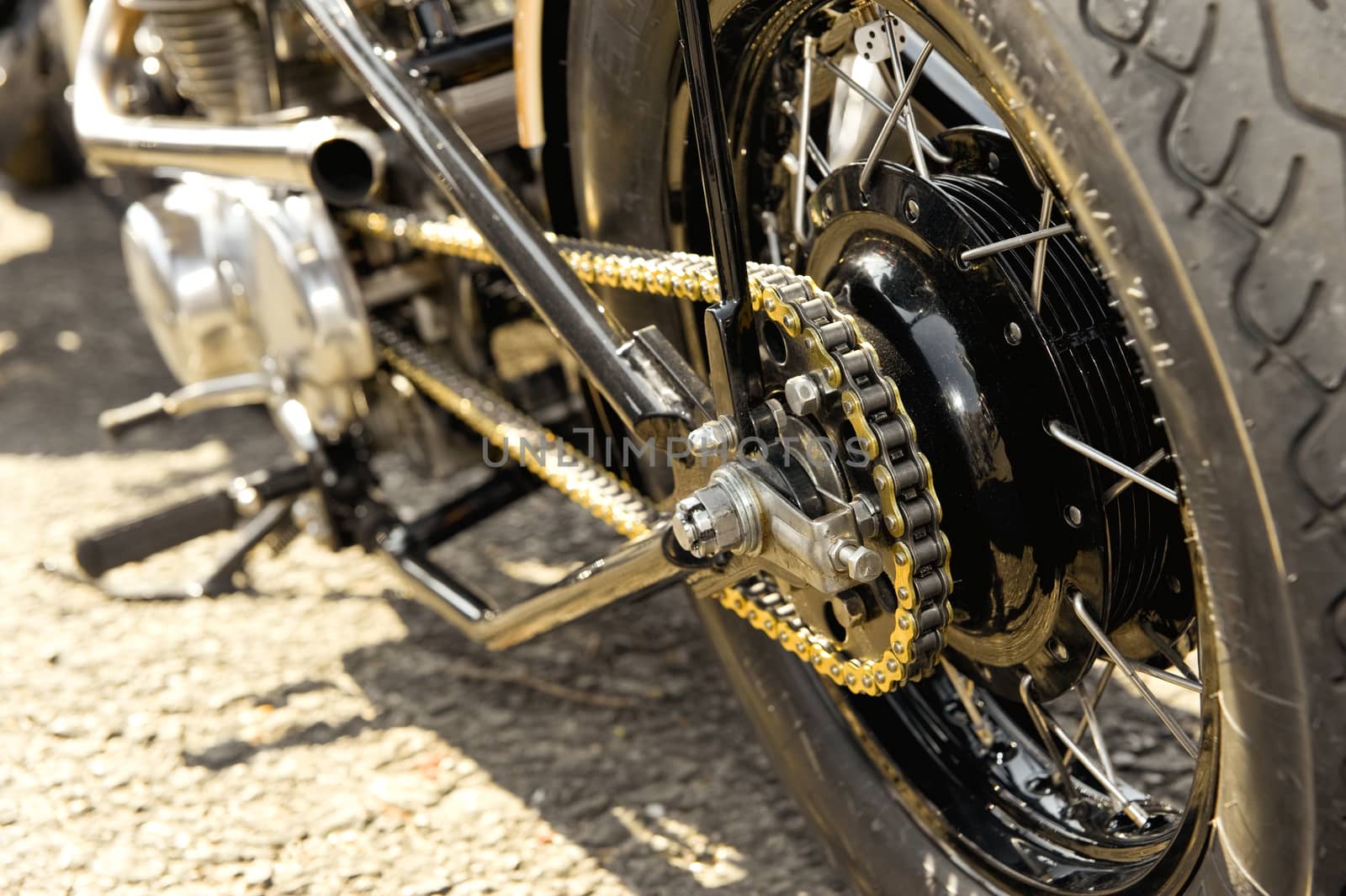 motorcycle wheel and drive-chain with golden toned hightlights