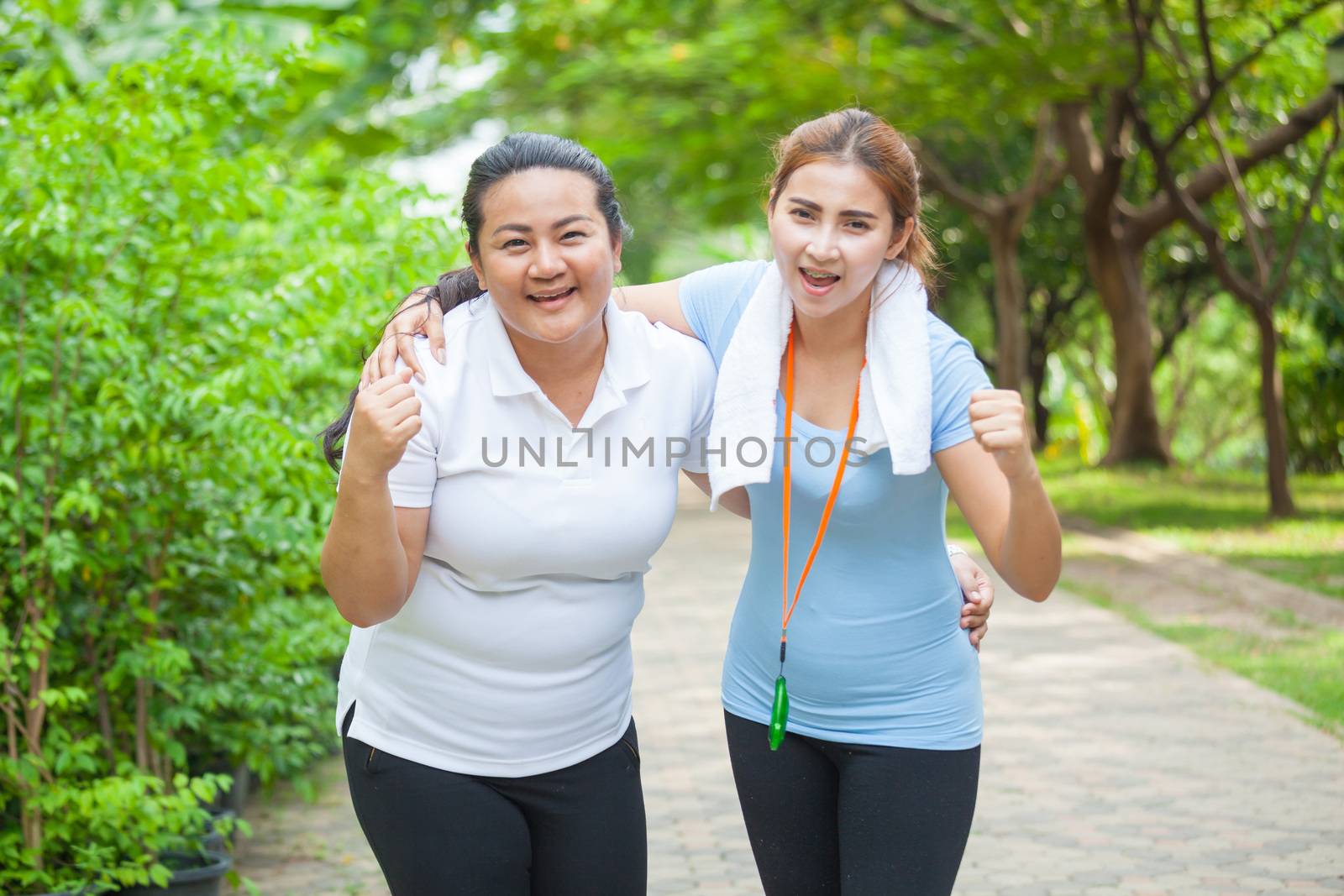 Portrait of two fit young women smiling in a bright outdoor