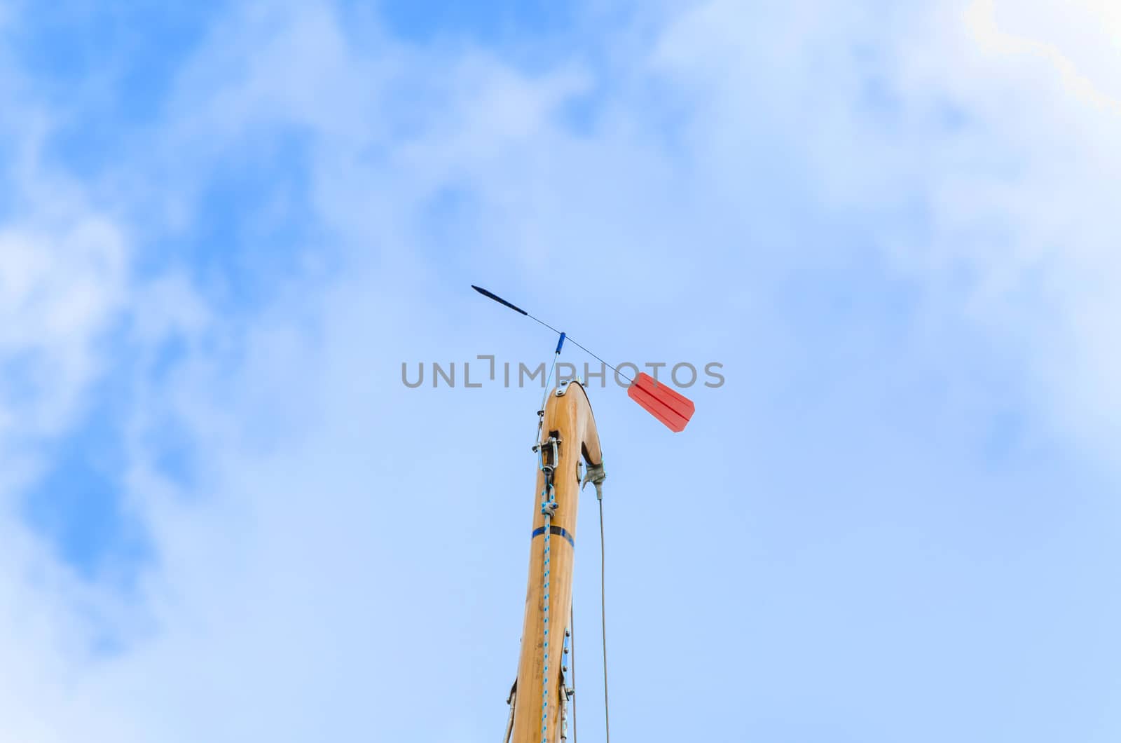 Sailboat mast with red Verklickerer against blue sky.