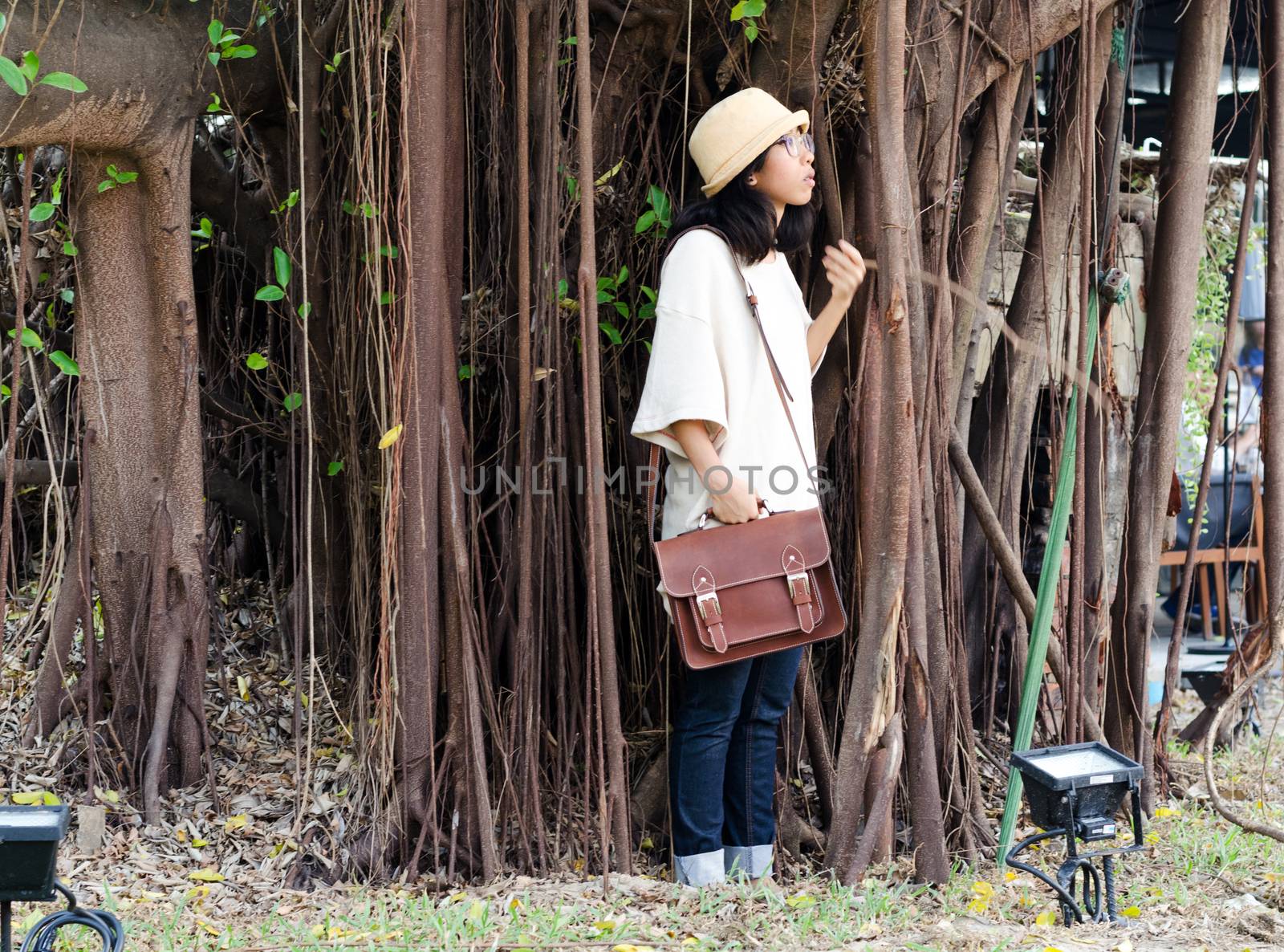 Fashion girl with handbag on banyan tree background