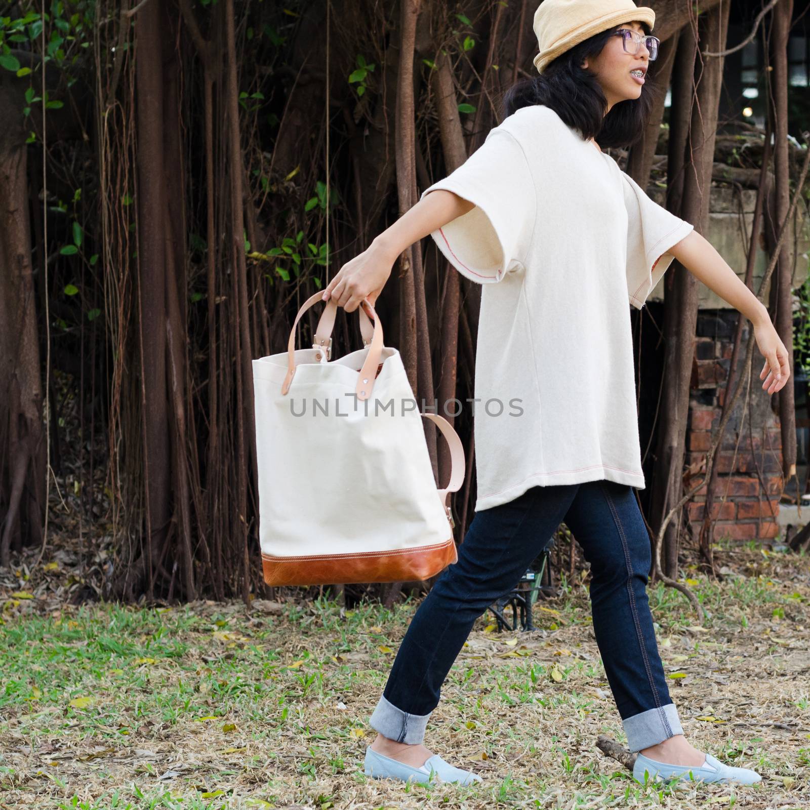 Funny girl with handbag on nature background by siraanamwong