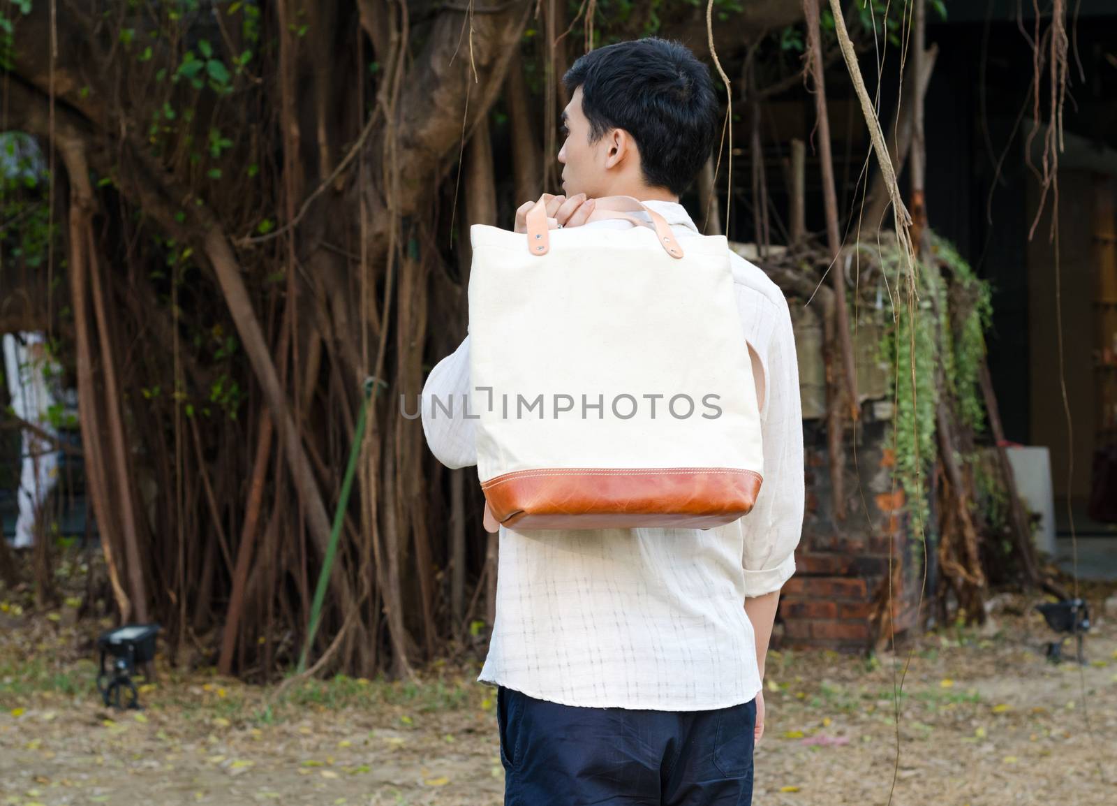 Fashion man with canvas bag on nature background