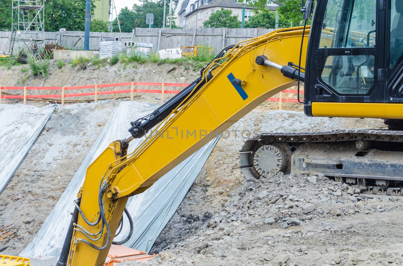 Large backhoe on construction site boundary at Excavation