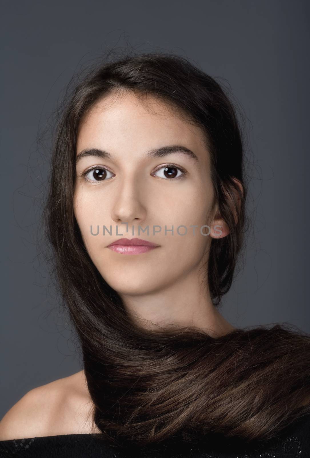 portrait of a woman with brown hair and brown eyes - isolated on gray