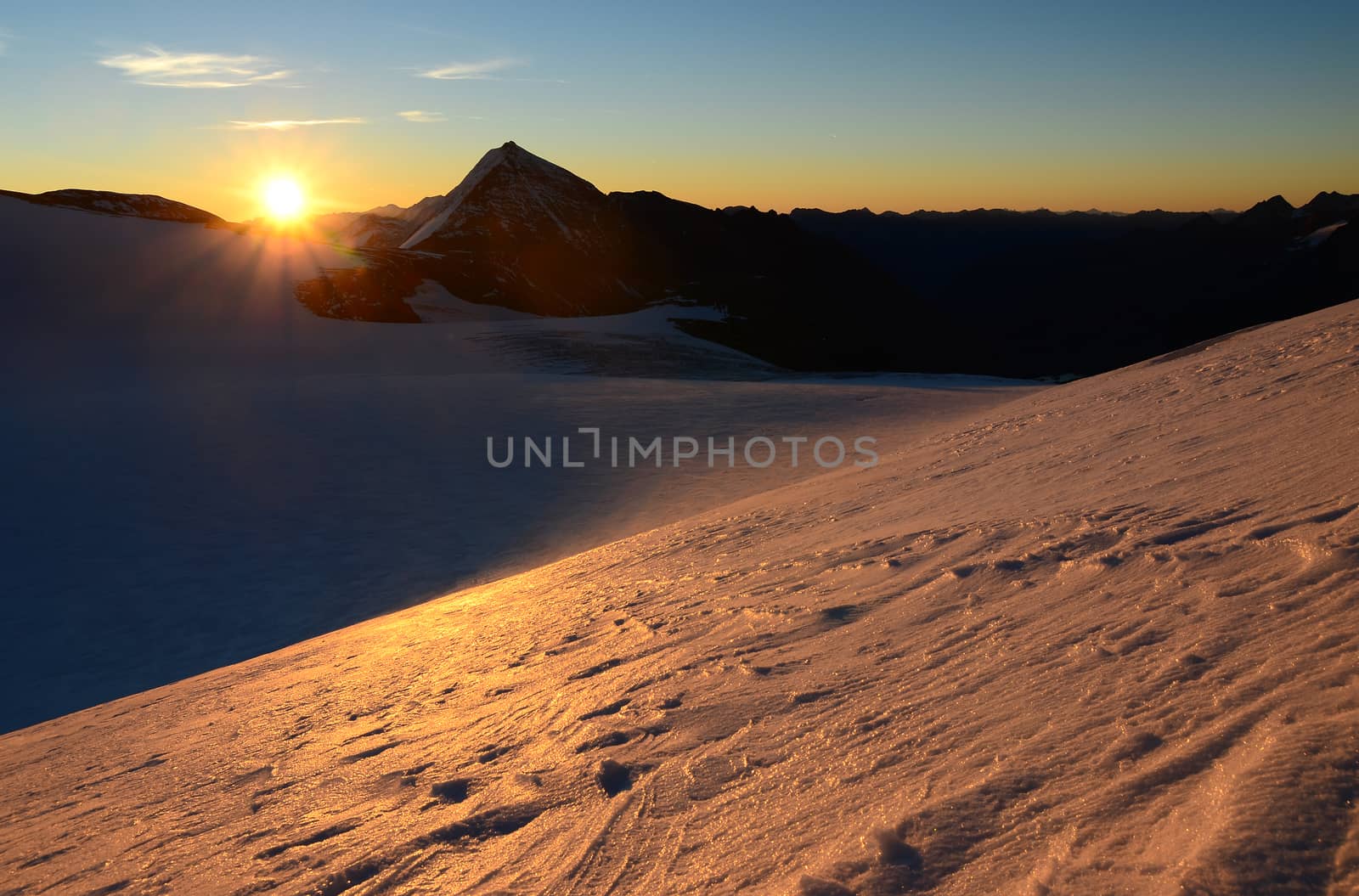 Sunrise in high mountains above the glacier