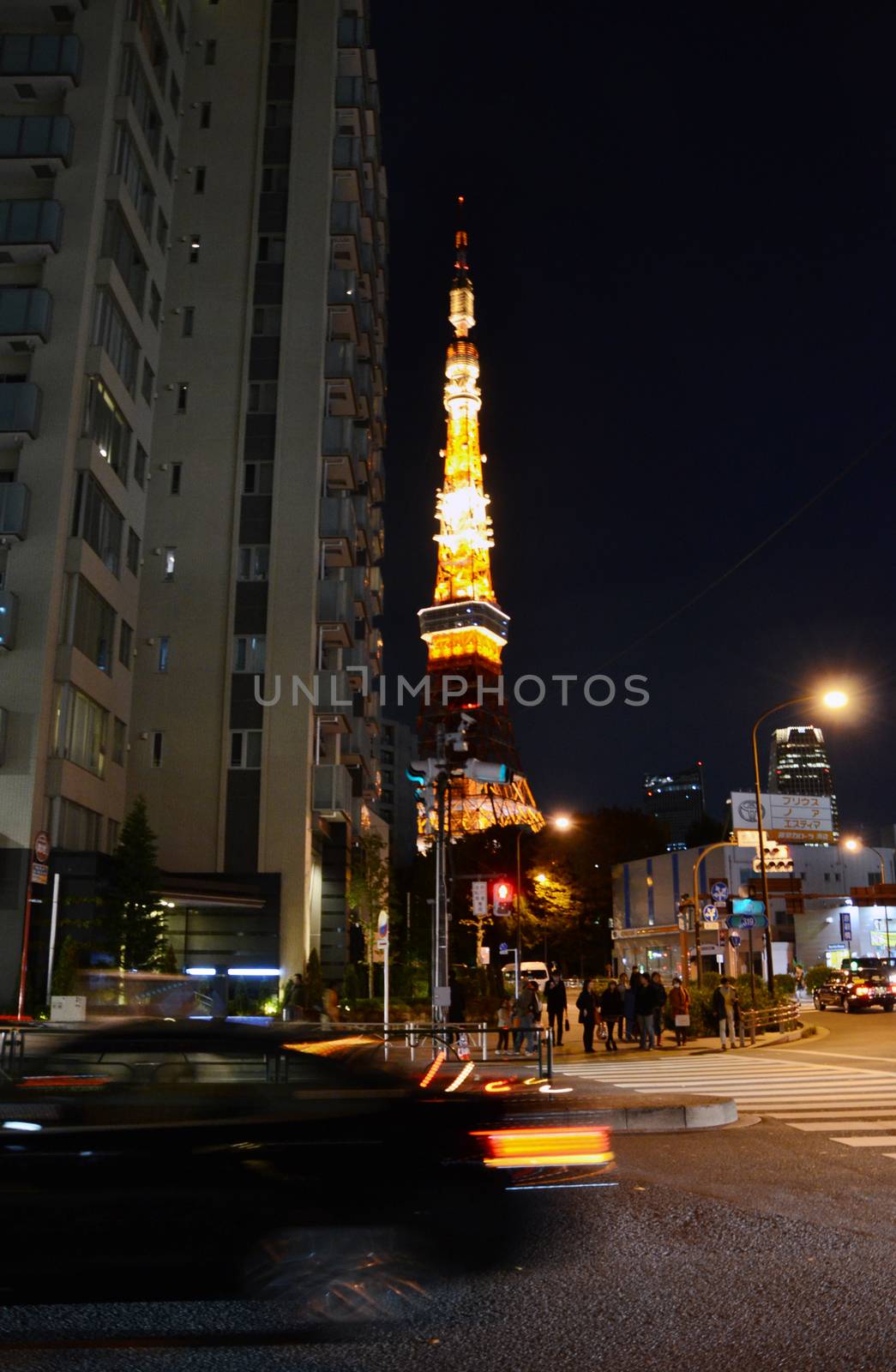 Tokyo, Japan - November 28, 2013: View of busy street at night with Tokyo Tower in the distance in Tokyo, Japan on November 28, 2013.