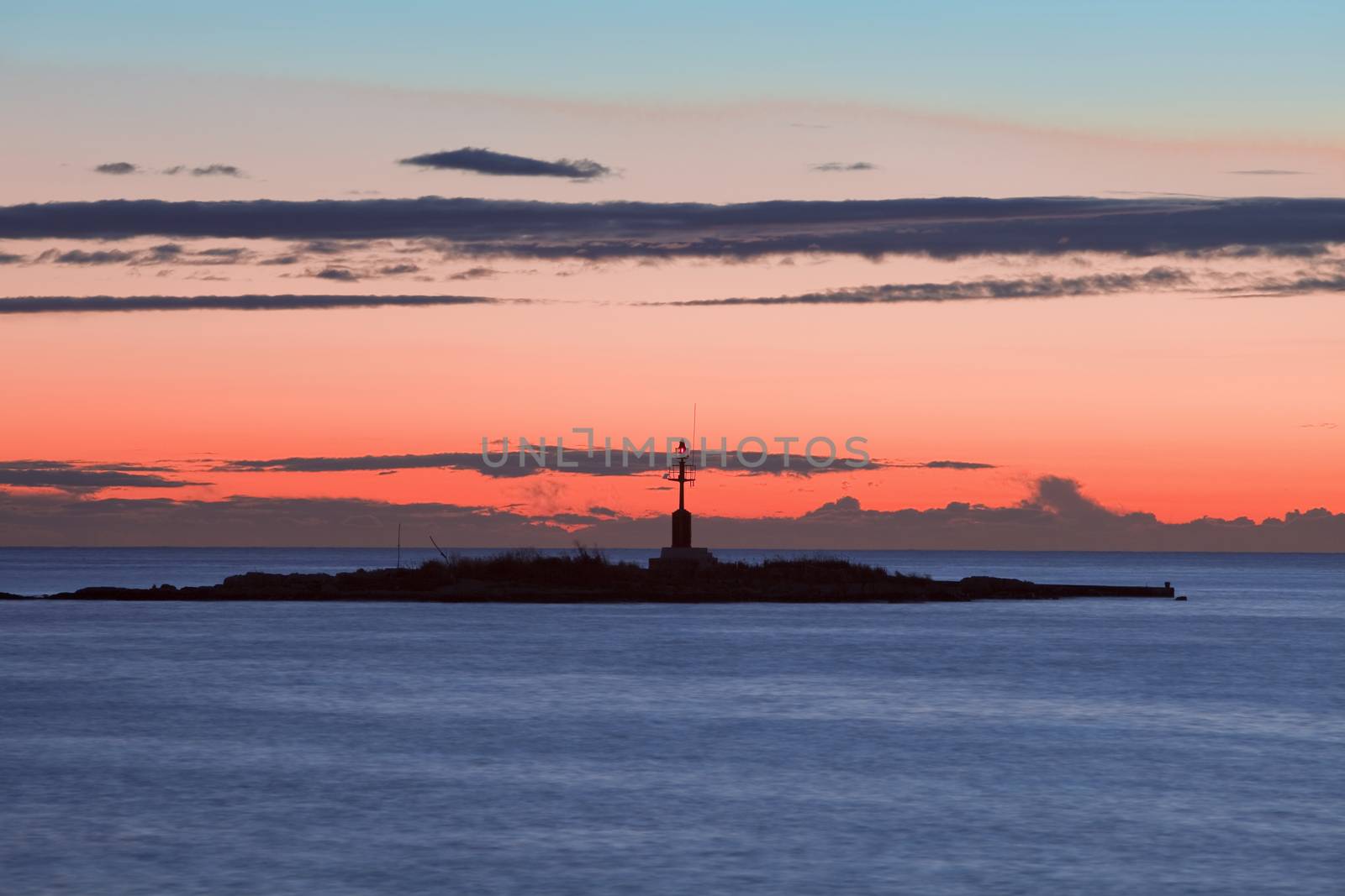 croatia - colorful sky and clouds after sunset over islet with lighthouse