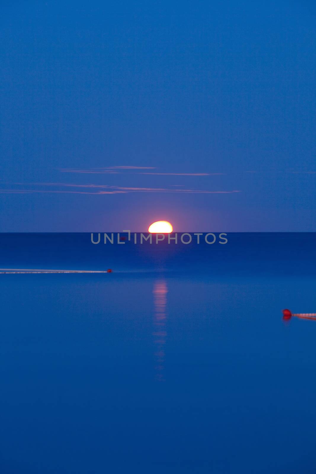 croatia, istria - full moon setting over adriatic sea at dawn