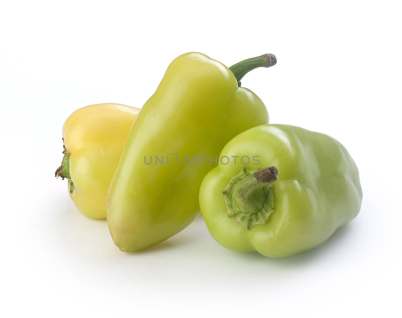 Three fresh green peppers on the white background