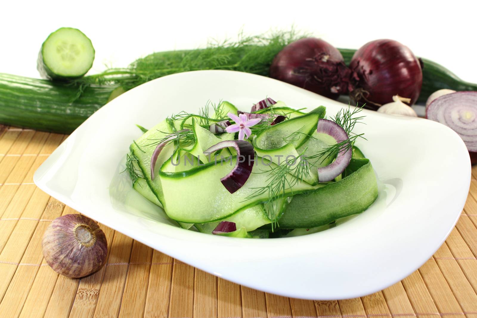 a bowl of cucumber salad with dill and red onions