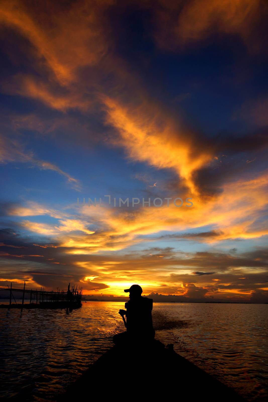 Lonely men silhouettes on sunset sky beautiful lagoon by Noppharat_th