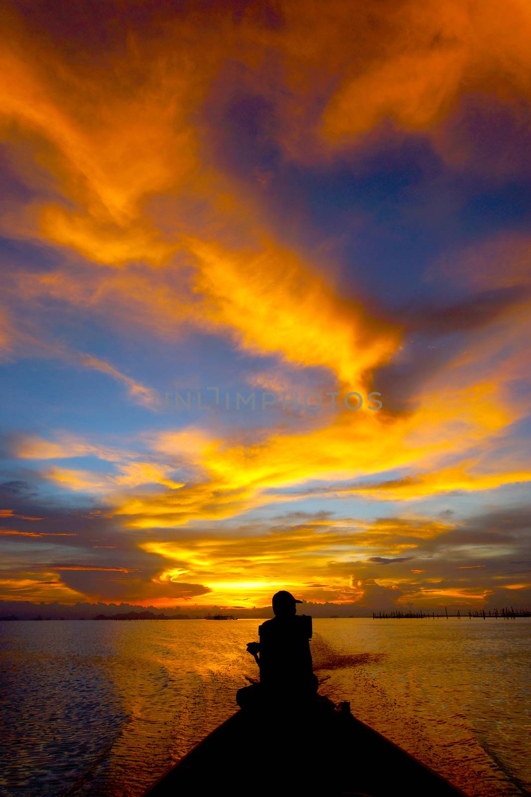 Lonely men silhouettes on sunset sky beautiful lagoon