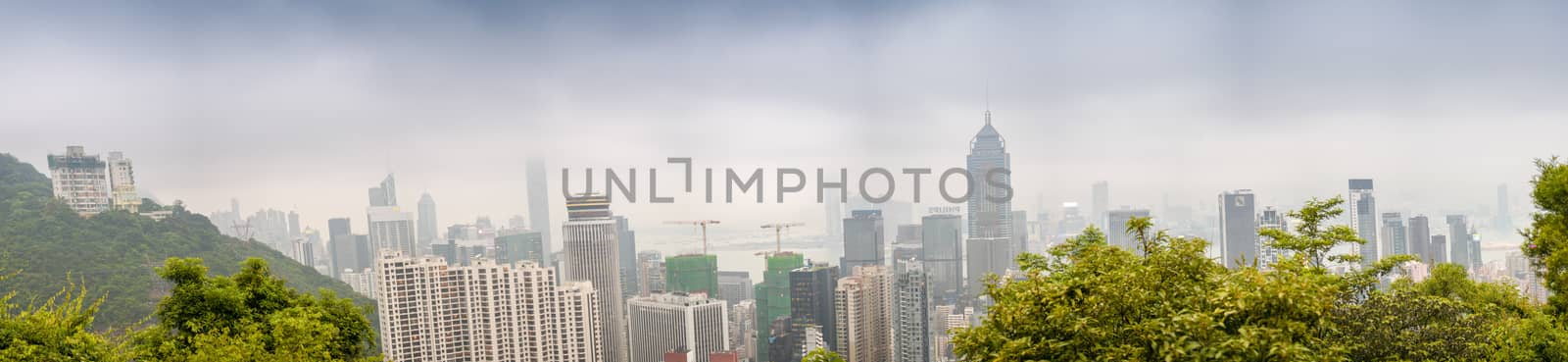 HONG KONG - MAY 12, 2014: Stunning panoramic view of Hong Kong Island and Kowloon on a cloudy day. Last year HK hosted more than 54 million visitors, most of them from the mainland.