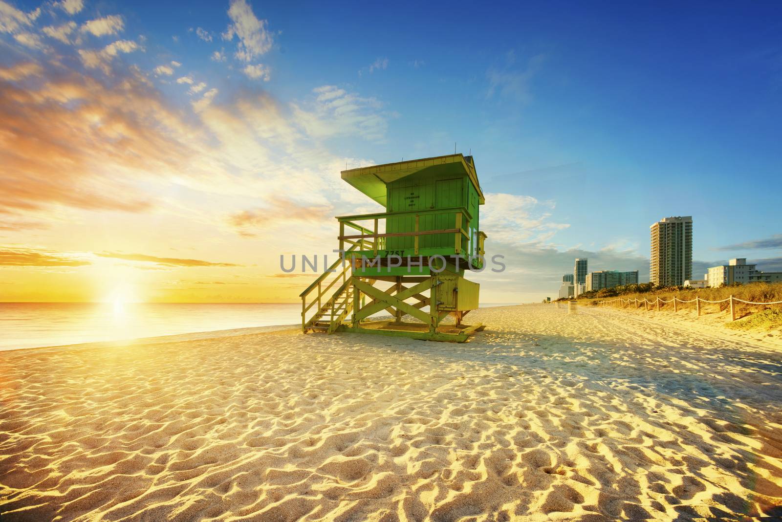 Miami South Beach sunrise with lifeguard tower and coastline with colorful cloud and blue sky. 