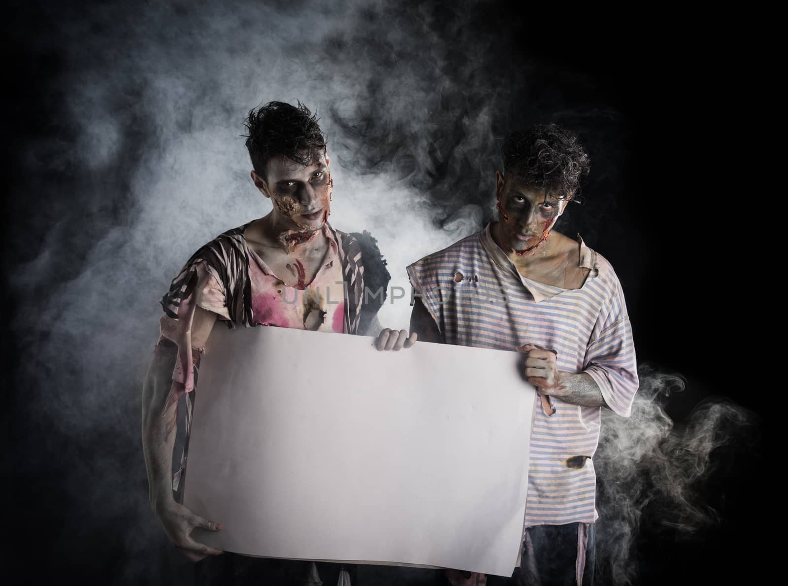 Two male zombies holding empty white banner, large copy-space for Halloween