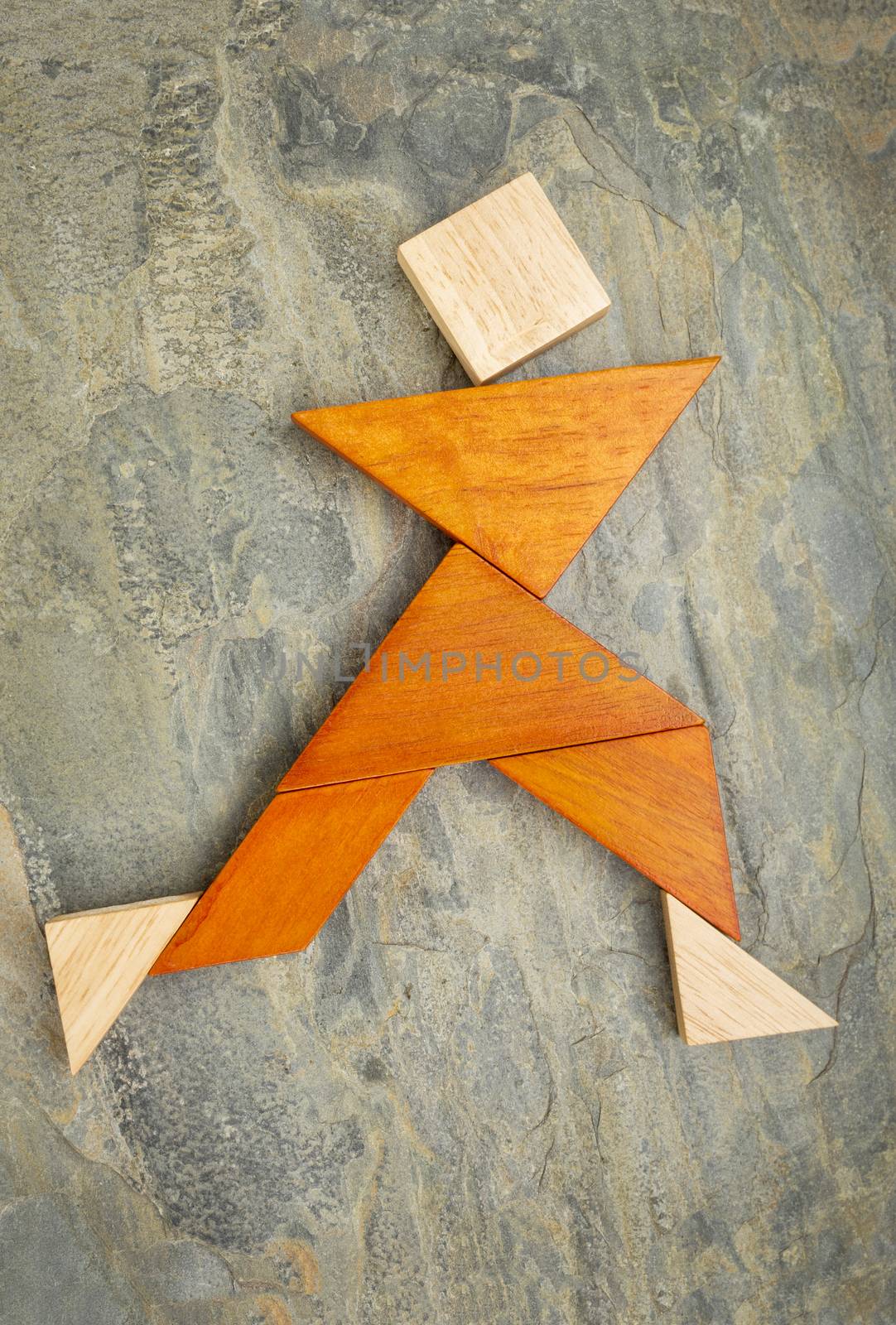 abstract of a dancing, running or walking figure built from seven tangram puzzle wooden pieces,, the artwork copyright by the photographer