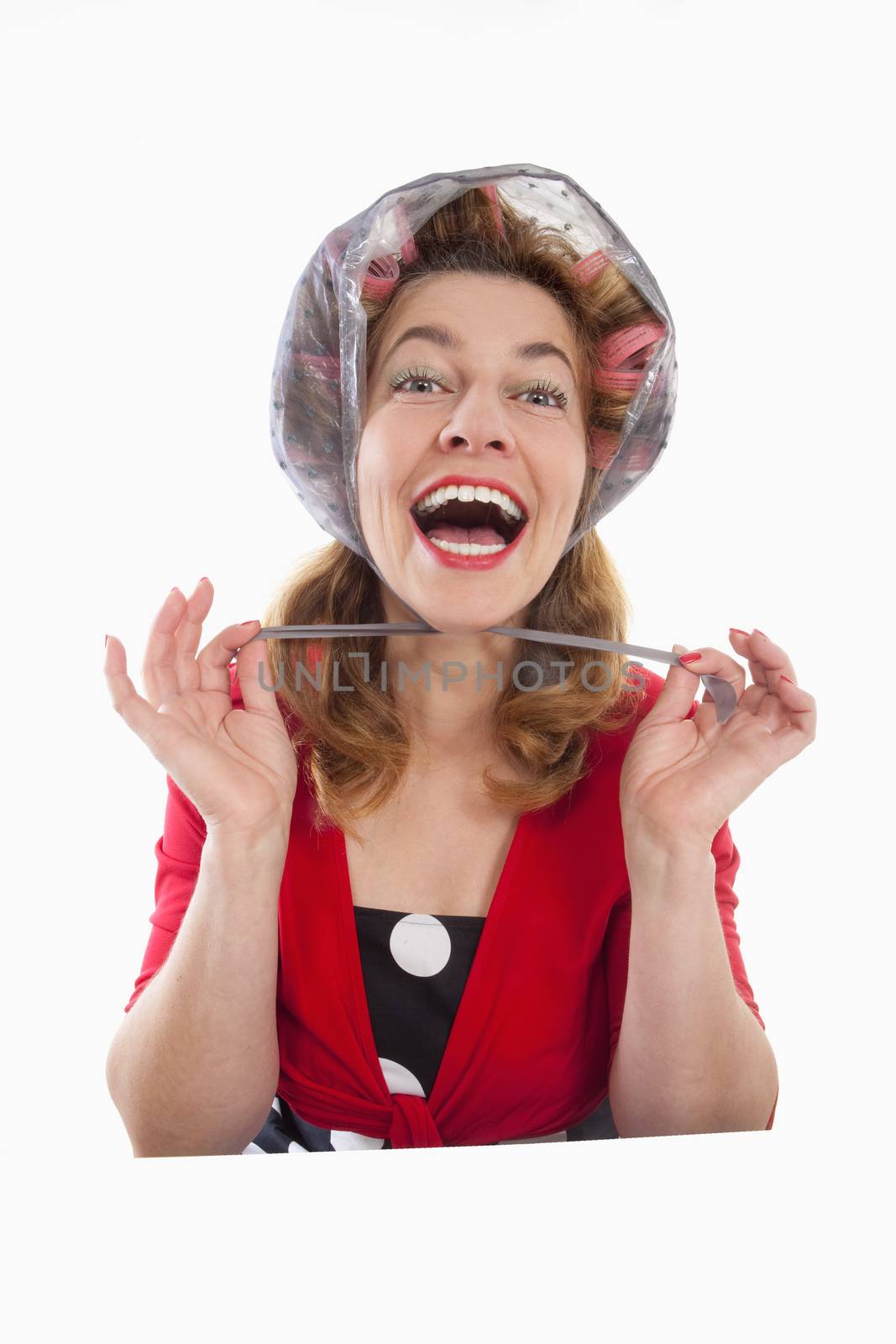 happy middle-aged woman in red with hair rollers - isolated on white