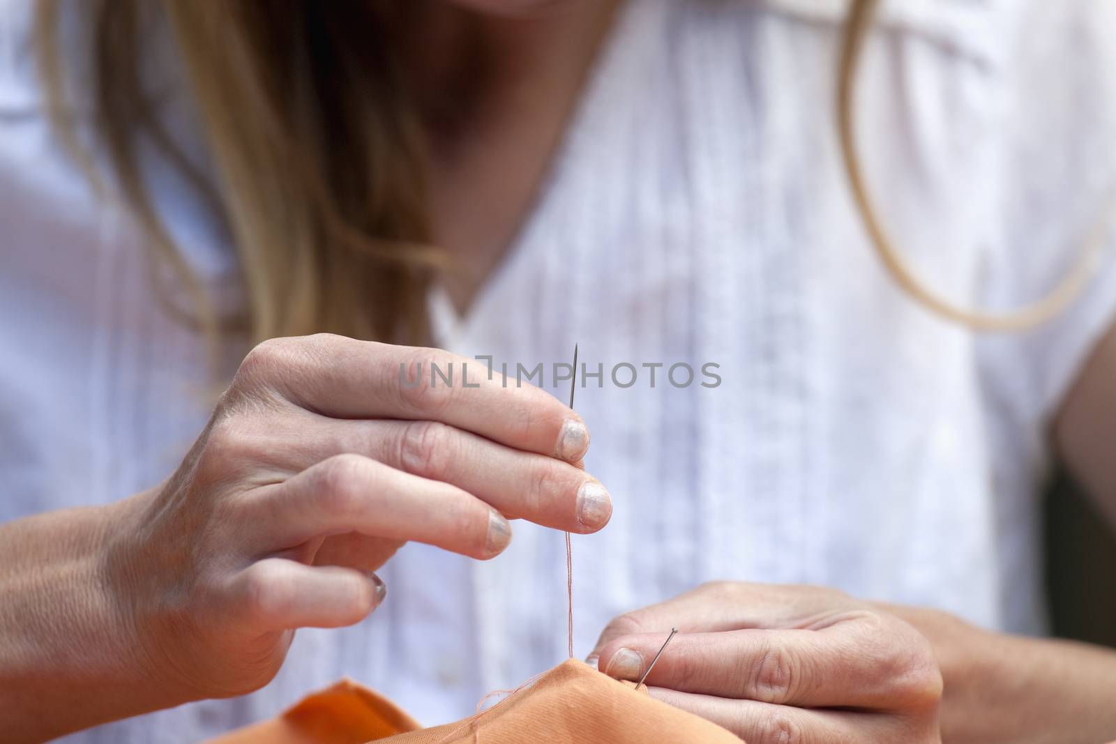closeup of hands sewing by courtyardpix