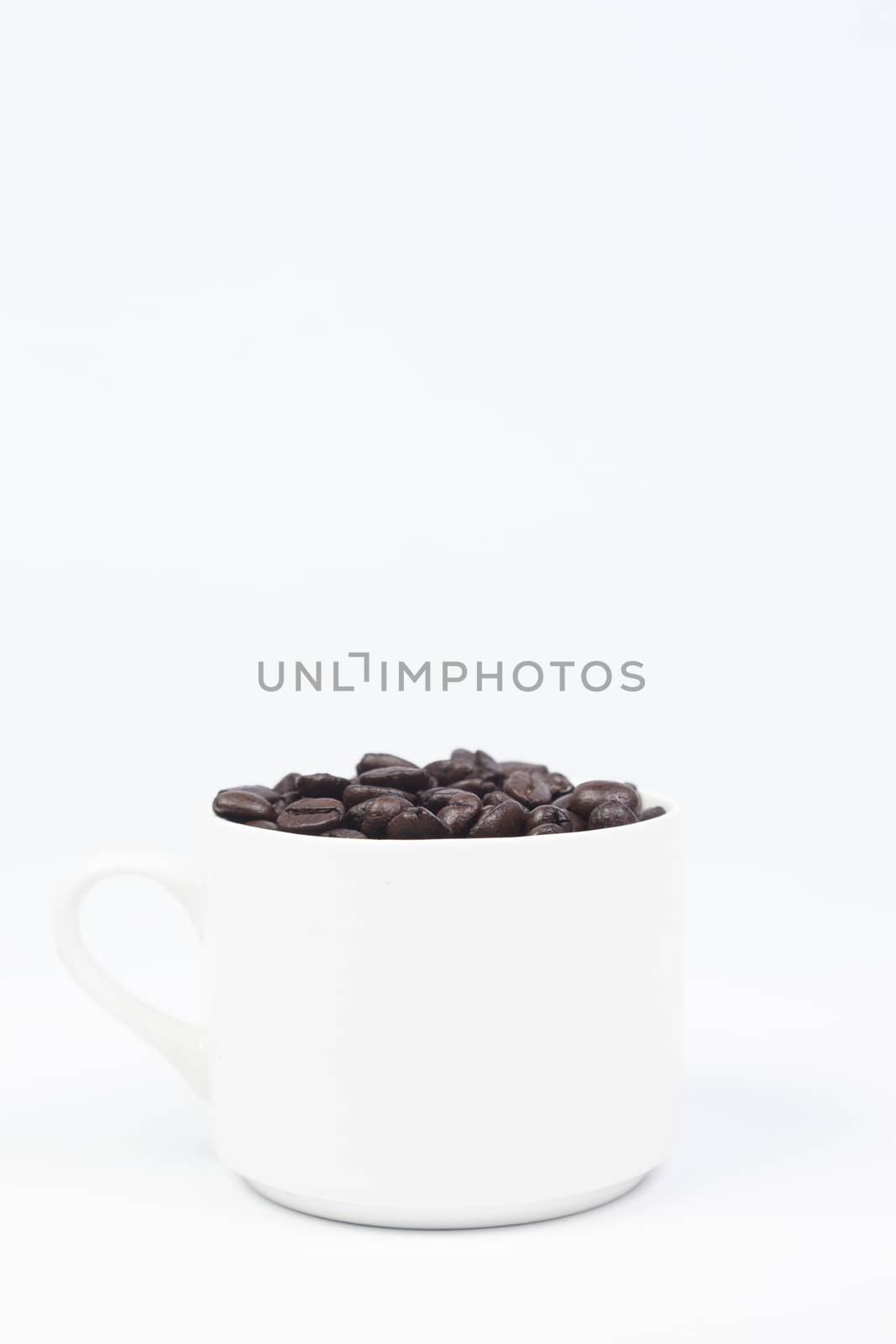 Coffee cup with coffee beans on white isolated background.