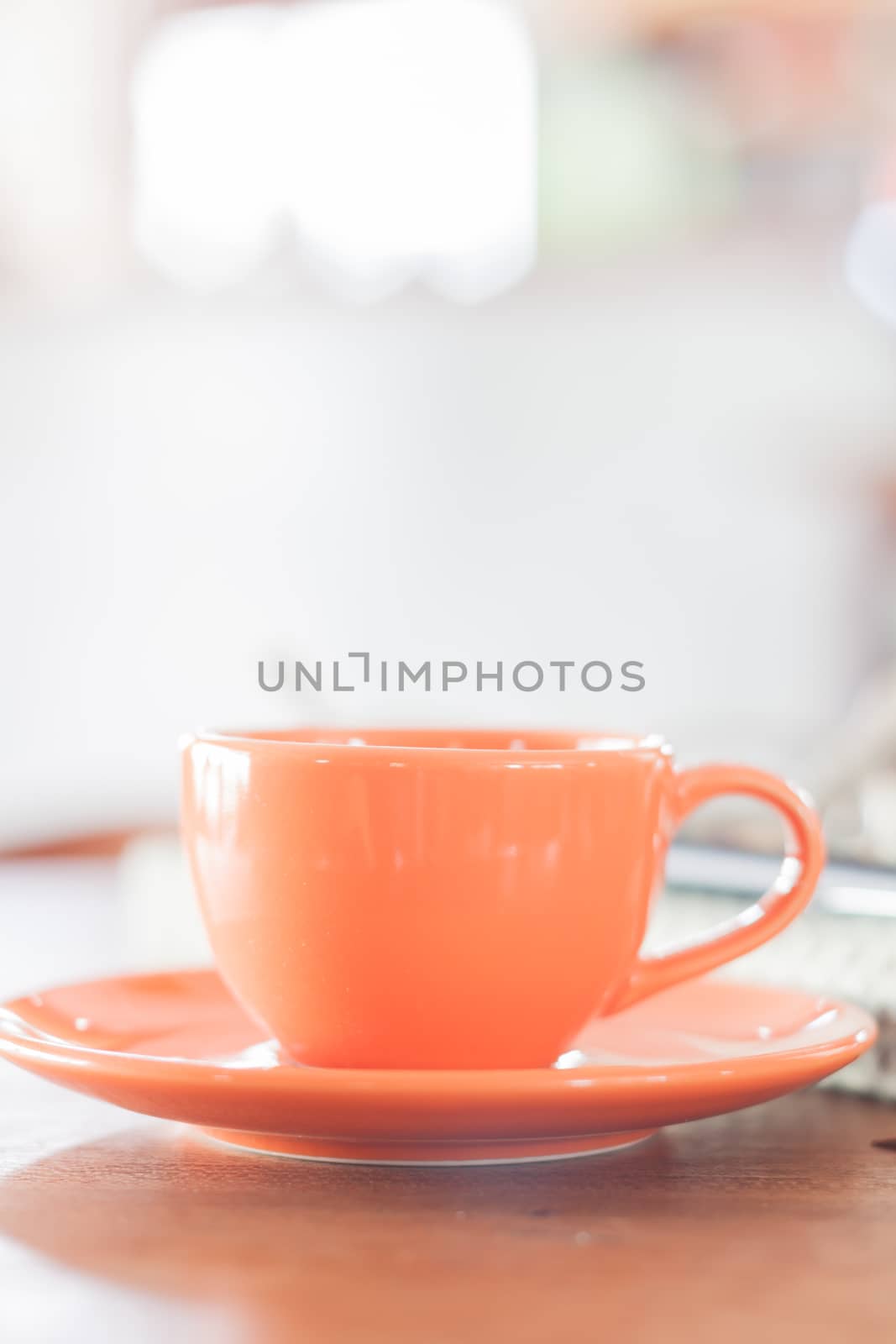 Mini orange coffee cup in coffee shop, stock photo