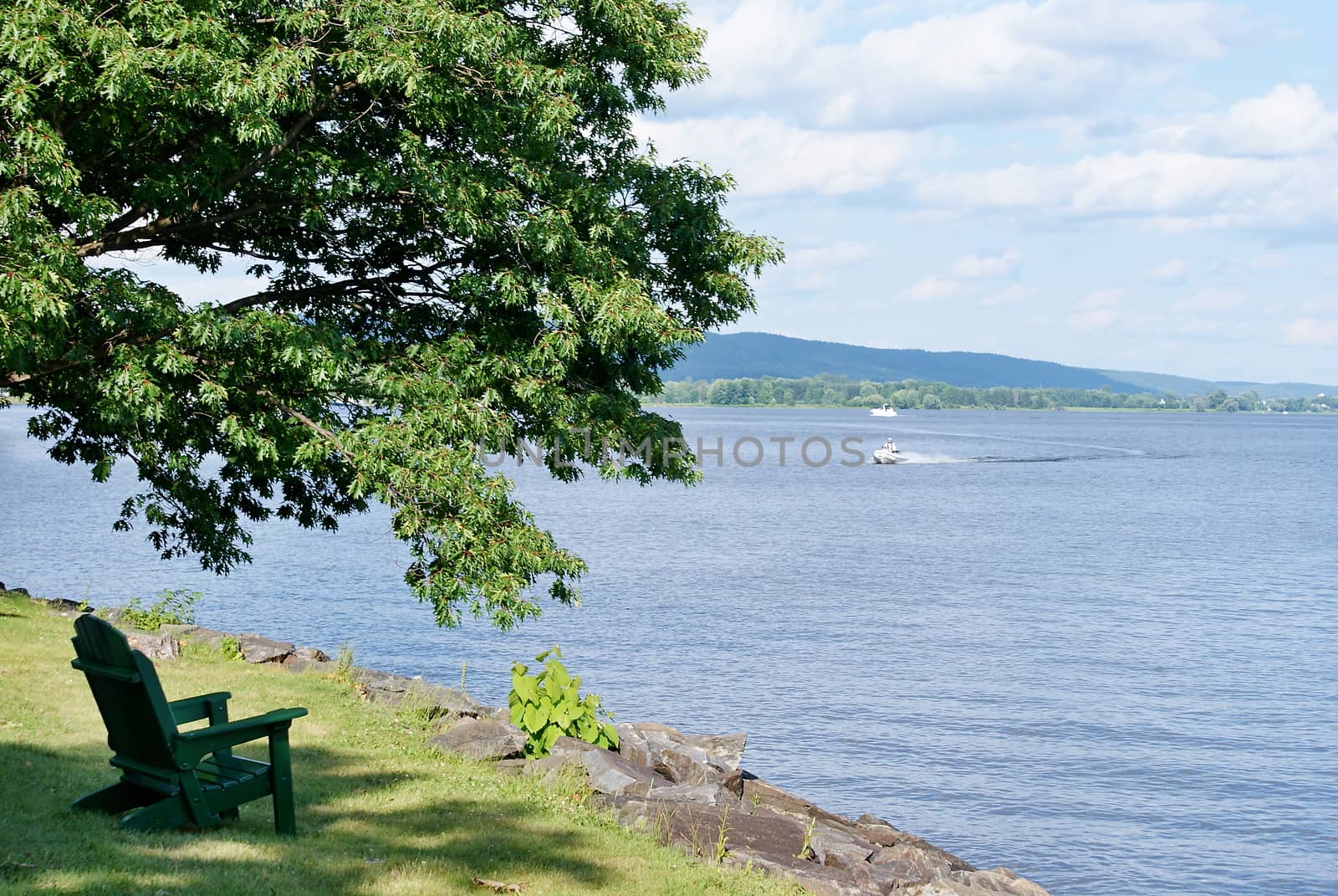 Photo shows Canadian countryside view with trees and lake.