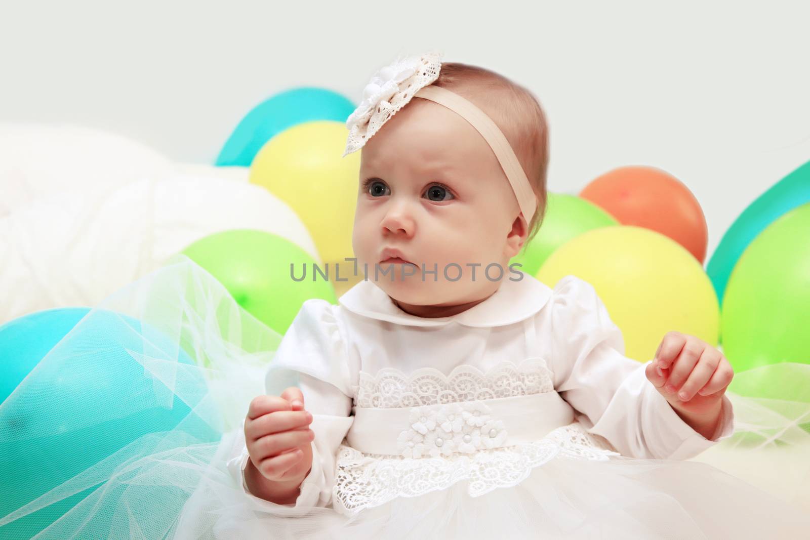 Beautiful little girl with balloons on white background
