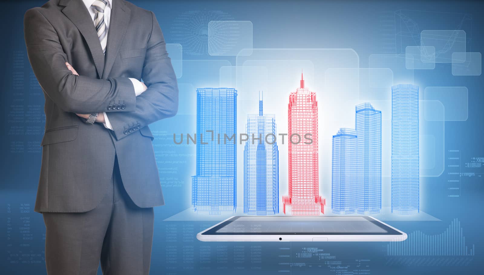 Businessman in suit stands with his arms crossed. Glowing wire-frame buildings on screen tablet pc as backdrop