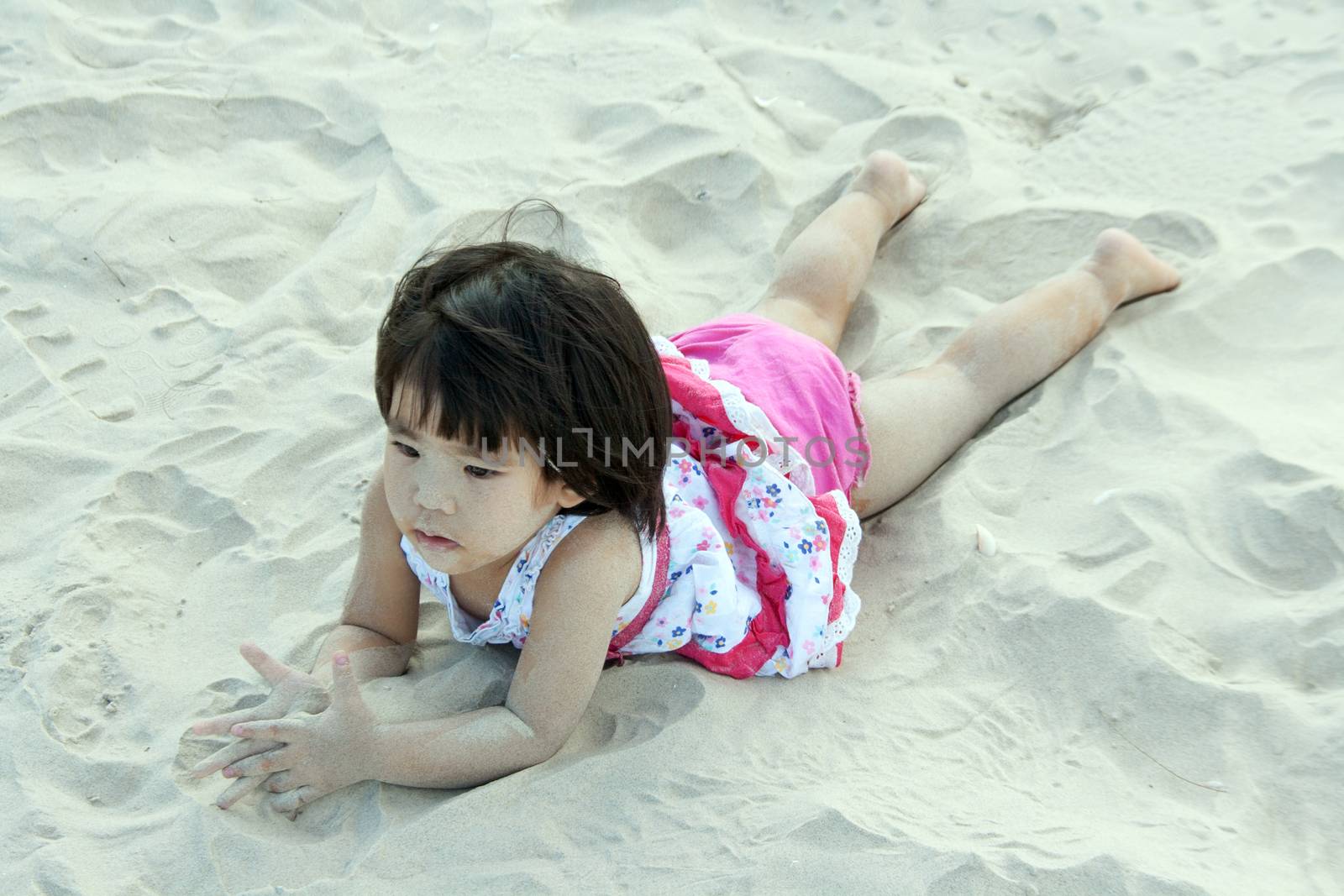 happy girl children playing on white sand by yanukit