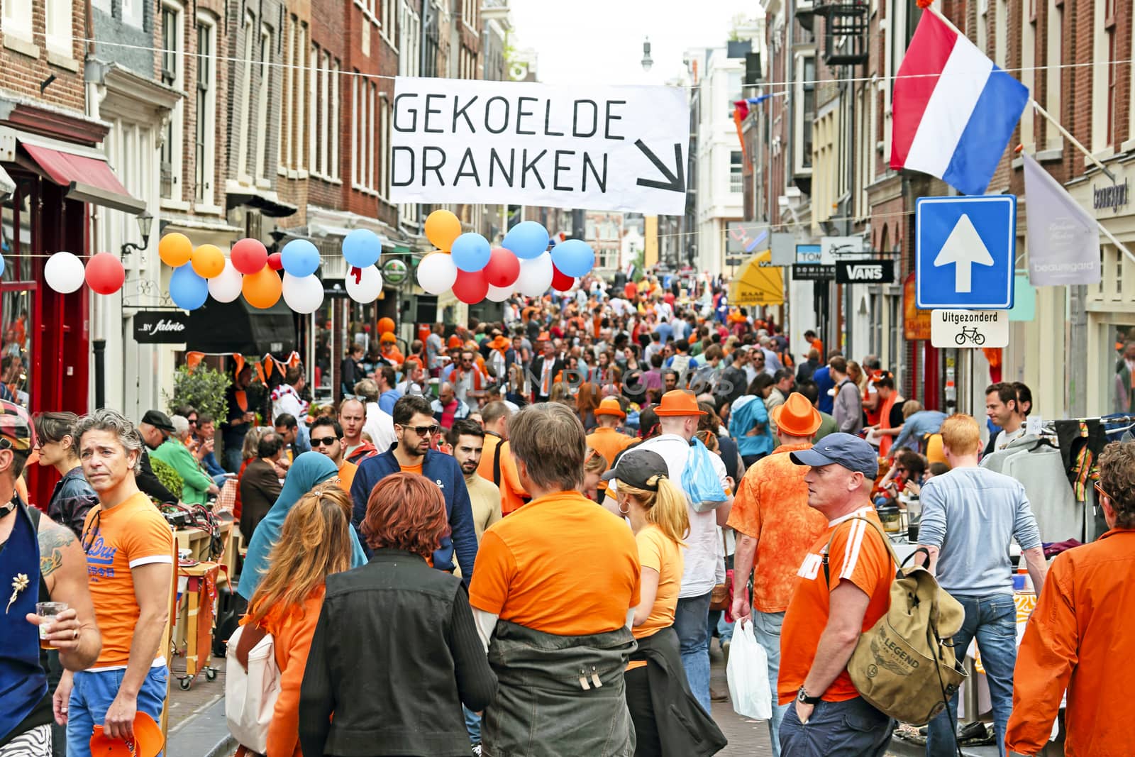 AMSTERDAM - APRIL 26: Amsterdam canals full of boats and people in orange during the celebration of kings day on April 26, 2014 in Amsterdam, The Netherlands