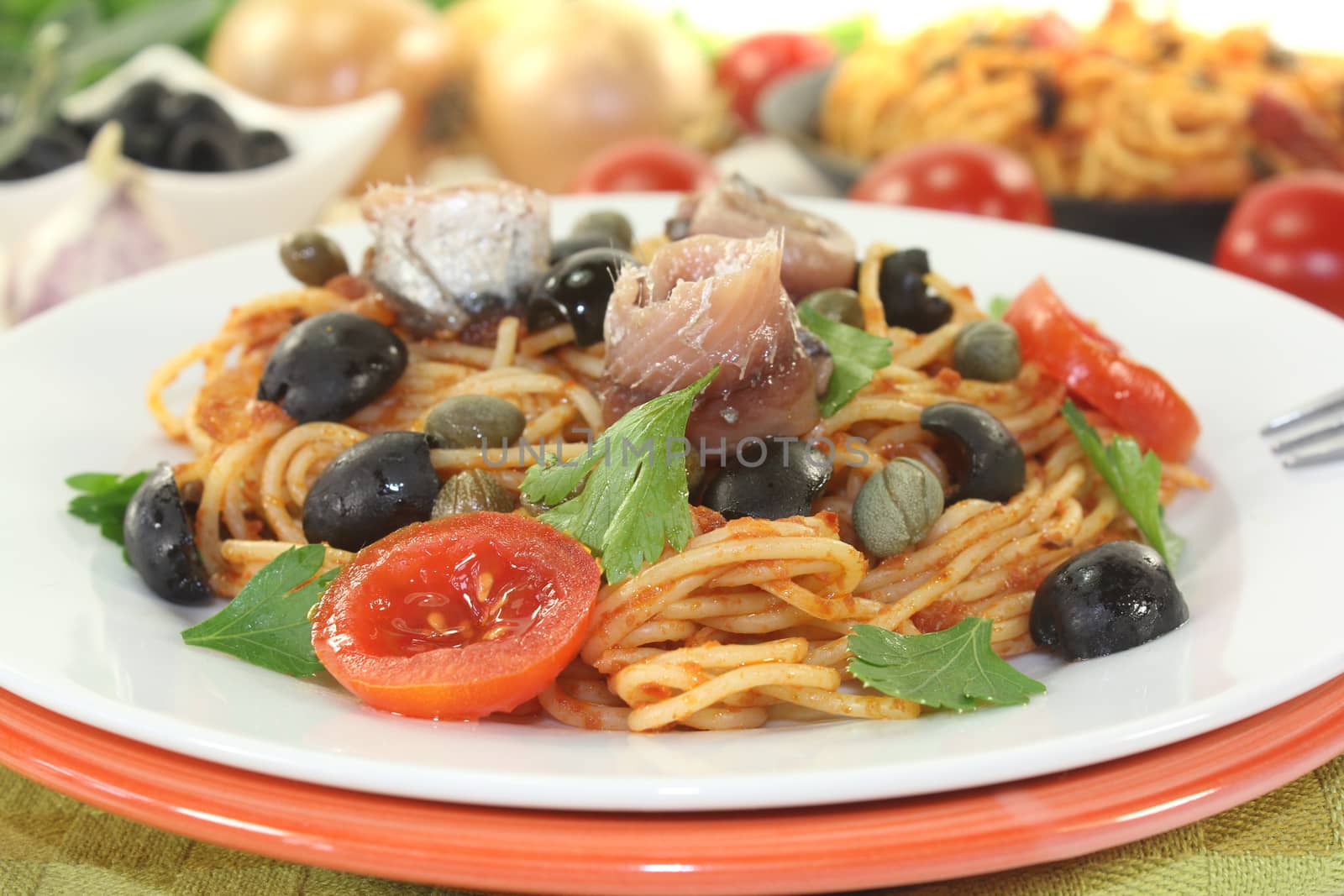 Spaghetti alla puttanesca with capers on light background