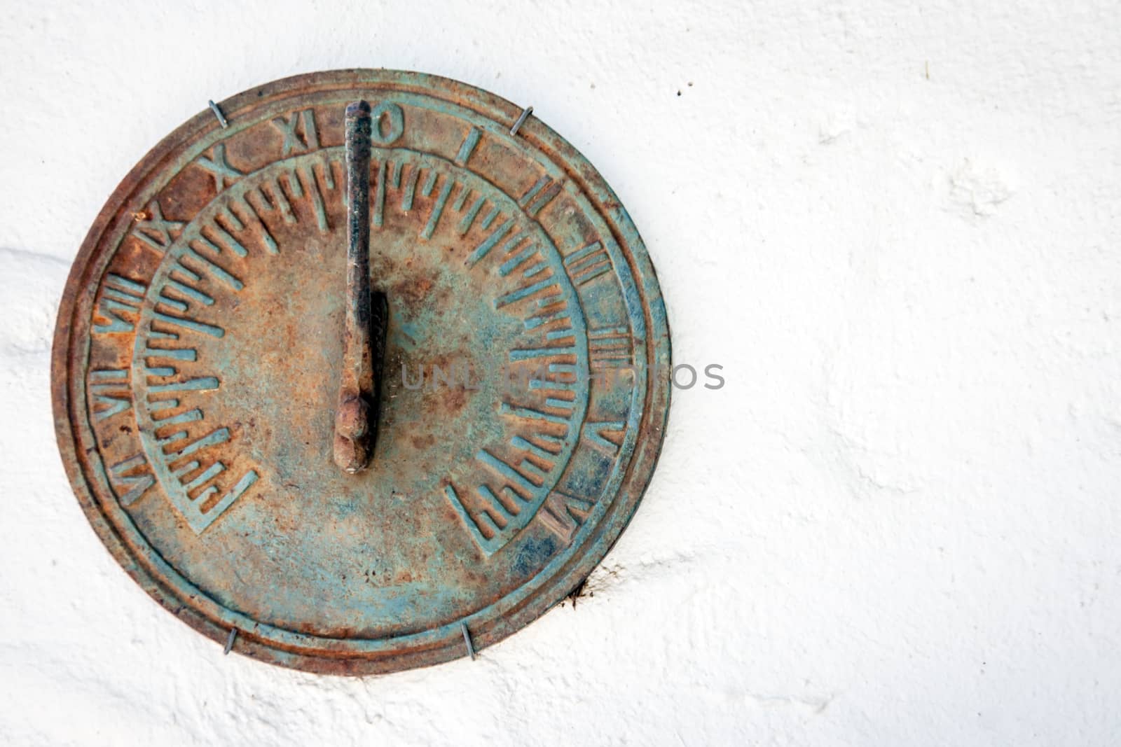 old iron sundial on white cement   by yanukit